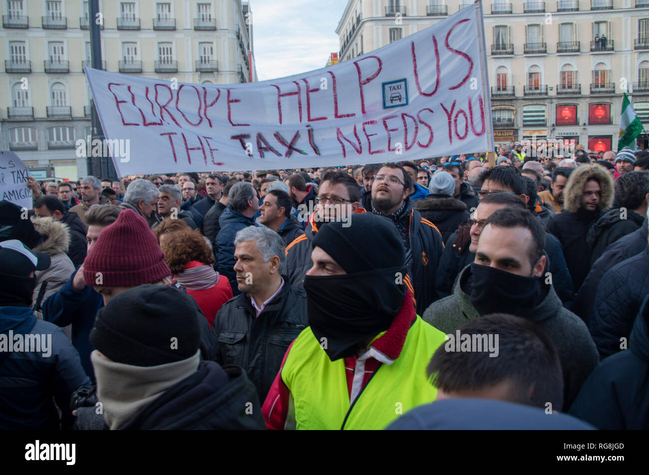 Madrid, Spain. 28th January 2019. Taxi drivers in Madrid have been on a strike for more than a week demanding the prohibition of Uber and Cabify in the Spanish capital-city.   Due to a lack of agreement, hundreds of taxi drivers protested at Puerta del Sol, Madrid’s central square.  In the picture taxi drivers are protesting with a placard asking support from the European Union. Credit: Lora Grigorova/Alamy Live News Stock Photo