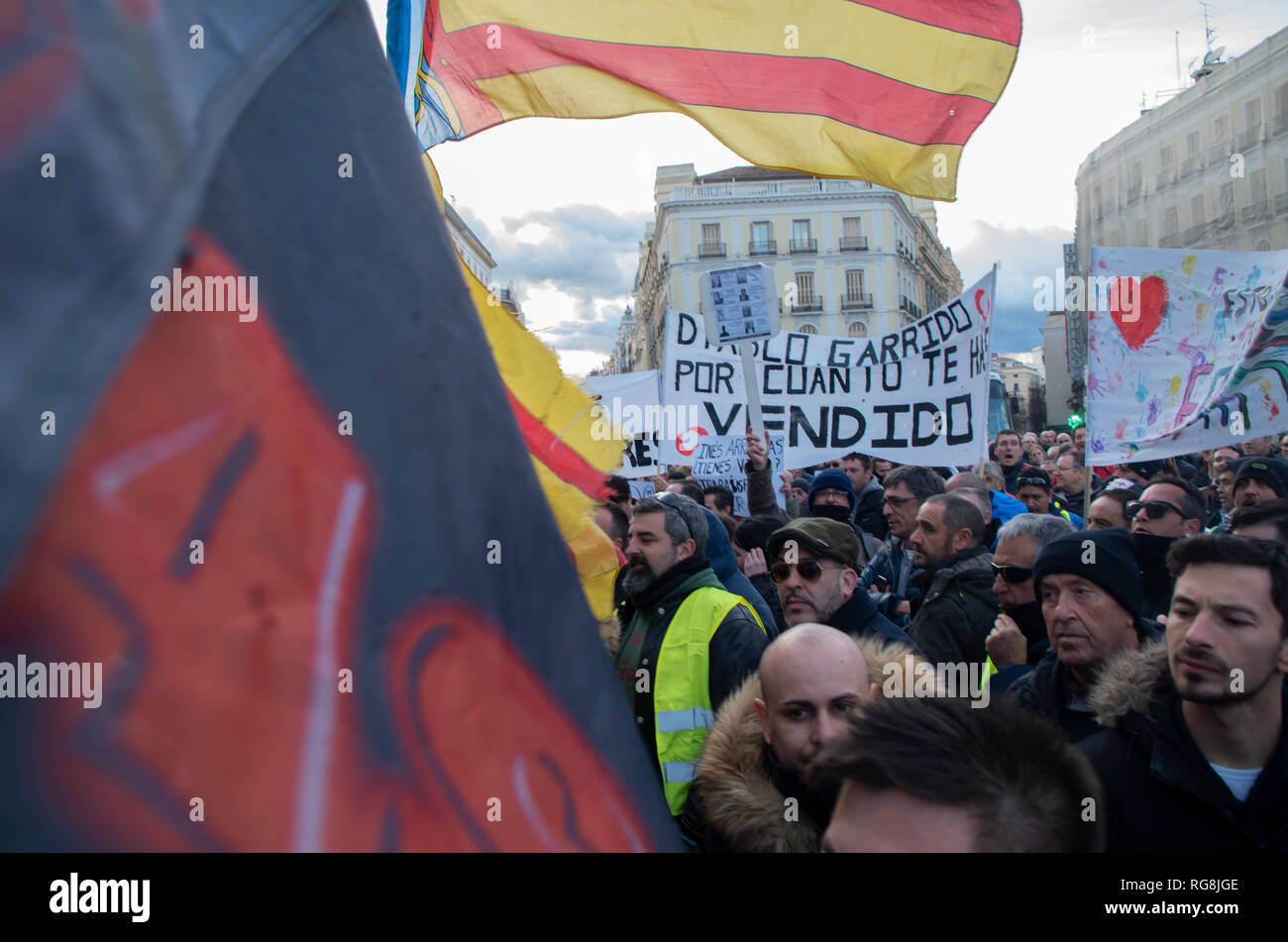 Madrid, Spain. 28th January 2019. Taxi drivers in Madrid have been on a strike for more than a week demanding the prohibition of Uber and Cabify in the Spanish capital-city.   Due to a lack of agreement, hundreds of taxi drivers protested at Puerta del Sol, Madrid’s central square.  In the picture taxi drivers protesting with the flag of the taxi unions. Credit: Lora Grigorova/Alamy Live News Stock Photo
