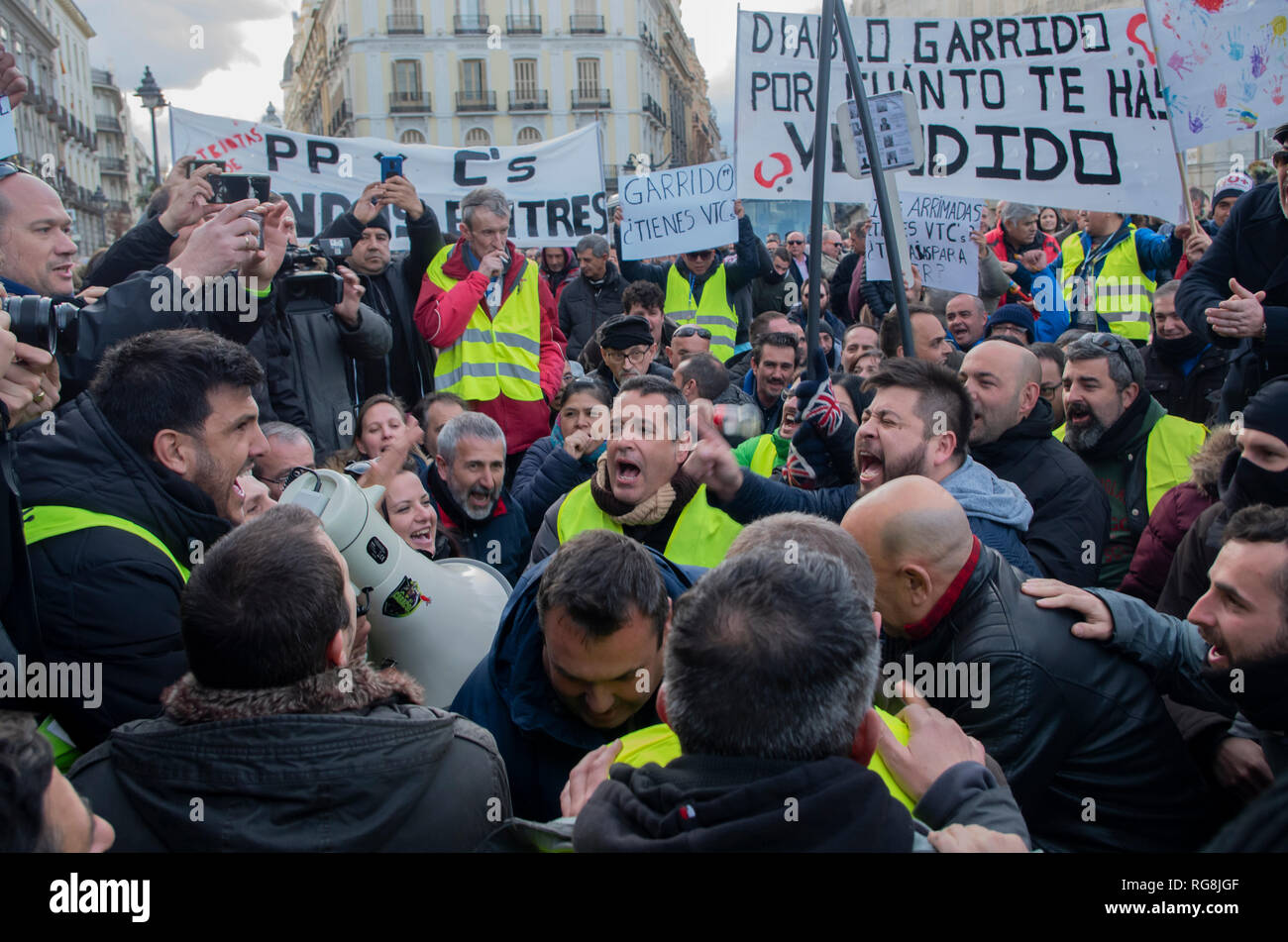 Madrid, Spain. 28th January 2019. Taxi drivers in Madrid have been on a strike for more than a week demanding the prohibition of Uber and Cabify in the Spanish capital-city.   Due to a lack of agreement, hundreds of taxi drivers protested at Puerta del Sol, Madrid’s central square.  In the pictures taxi drivers are angrily protesting. Credit: Lora Grigorova/Alamy Live News Stock Photo