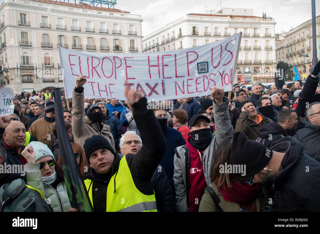 Madrid, Spain. 28th January 2019. Taxi drivers in Madrid have been on a strike for more than a week demanding the prohibition of Uber and Cabify in the Spanish capital-city.   Due to a lack of agreement, hundreds of taxi drivers protested at Puerta del Sol, Madrid’s central square.  In the picture taxi drivers are raising their fists to protest. Credit: Lora Grigorova/Alamy Live News Stock Photo