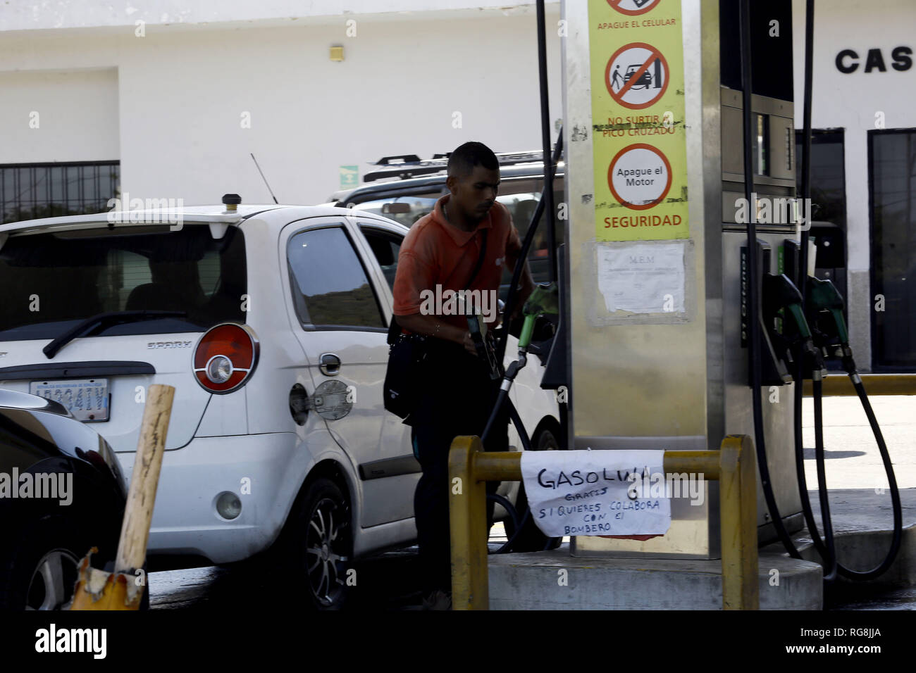 San Diego, Carabobo, Venezuela. 28th Jan, 2019. January 28, 2019. At the Castillito service station, Mauro Ramirez, an island operator, decided to place a notice to customers where he offers gasoline for free and asks them to collaborate with the ''fireman'', given the low cost of gasoline, explained that way he earns more money since his boss refuses to pay his salary since the fuel profit margin is not enough to cover the expenses. In the San Diego municipality of the Carabobo state. Photo: Juan Carlos Hernandez Credit: Juan Carlos Hernandez/ZUMA Wire/Alamy Live News Stock Photo