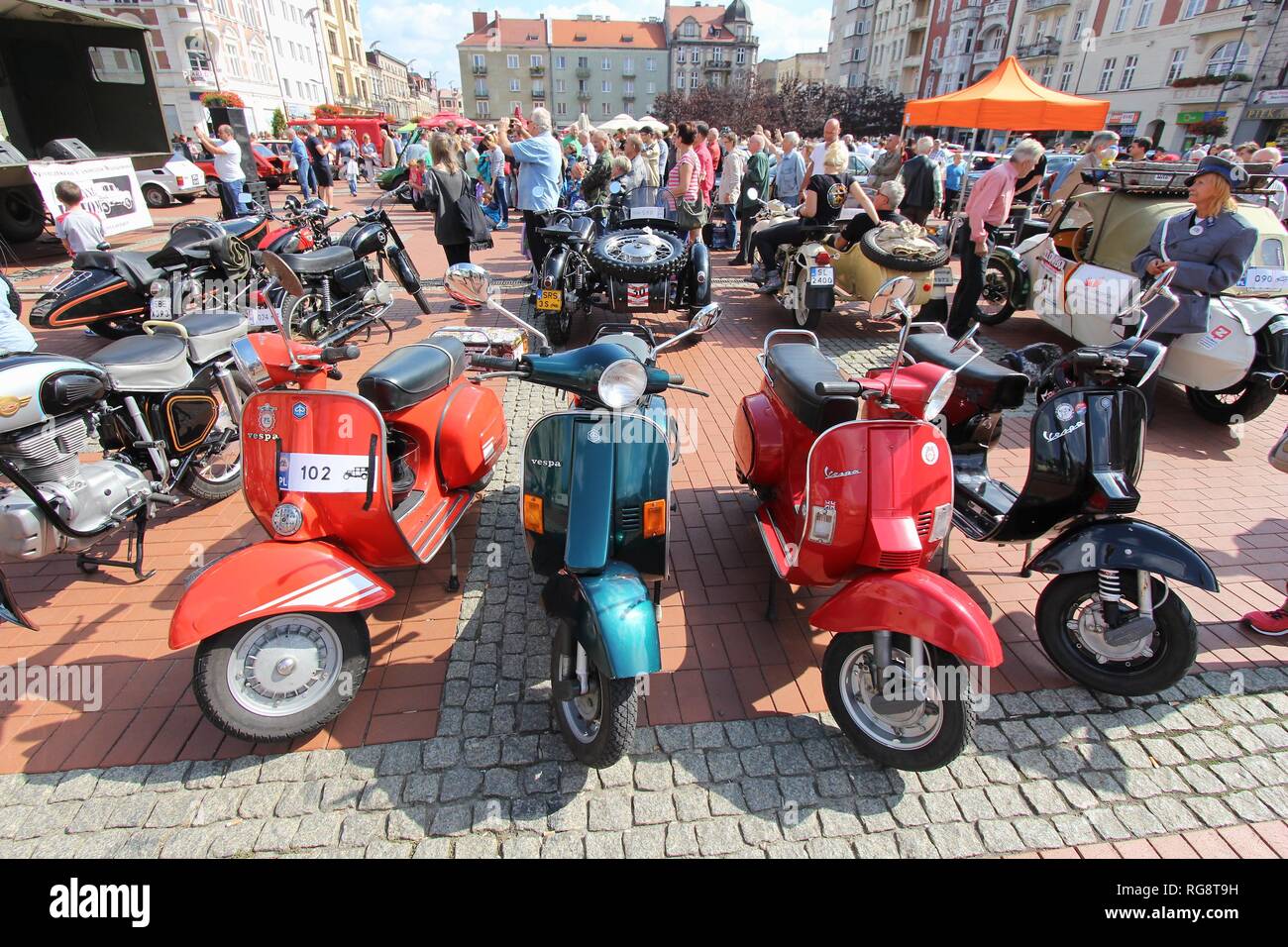 BYTOM, POLAND - SEPTEMBER 12, 2015: People admire Piaggio Vespa motorcycles during 12th Historic Vehicle Rally in Bytom. The annual vehicle parade is  Stock Photo
