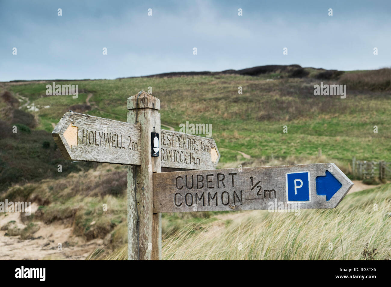 A wooden signpost giving directions for the South West Coast Path at ...