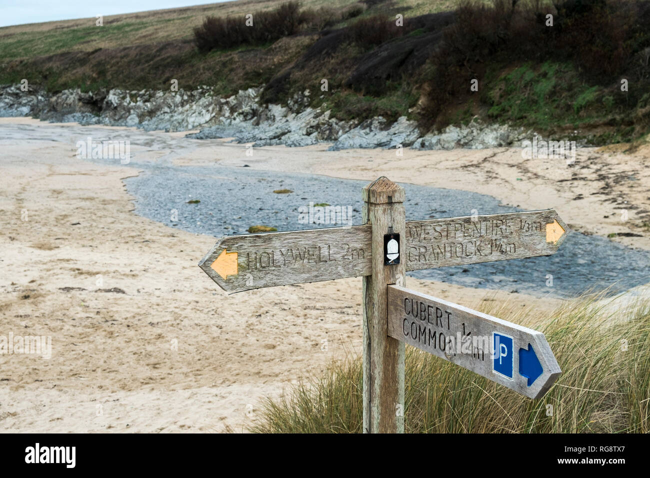 A wooden signpost giving directions for the South West Coast Path at ...