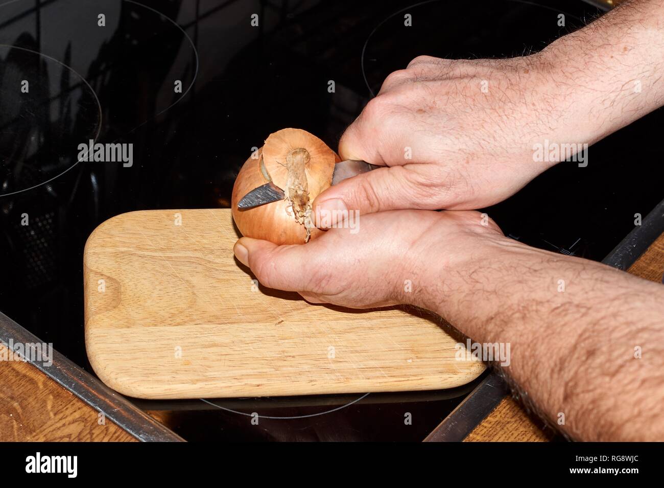 Chef slicing Onion, Allium cepa on the cutting board with a knife Stock ...