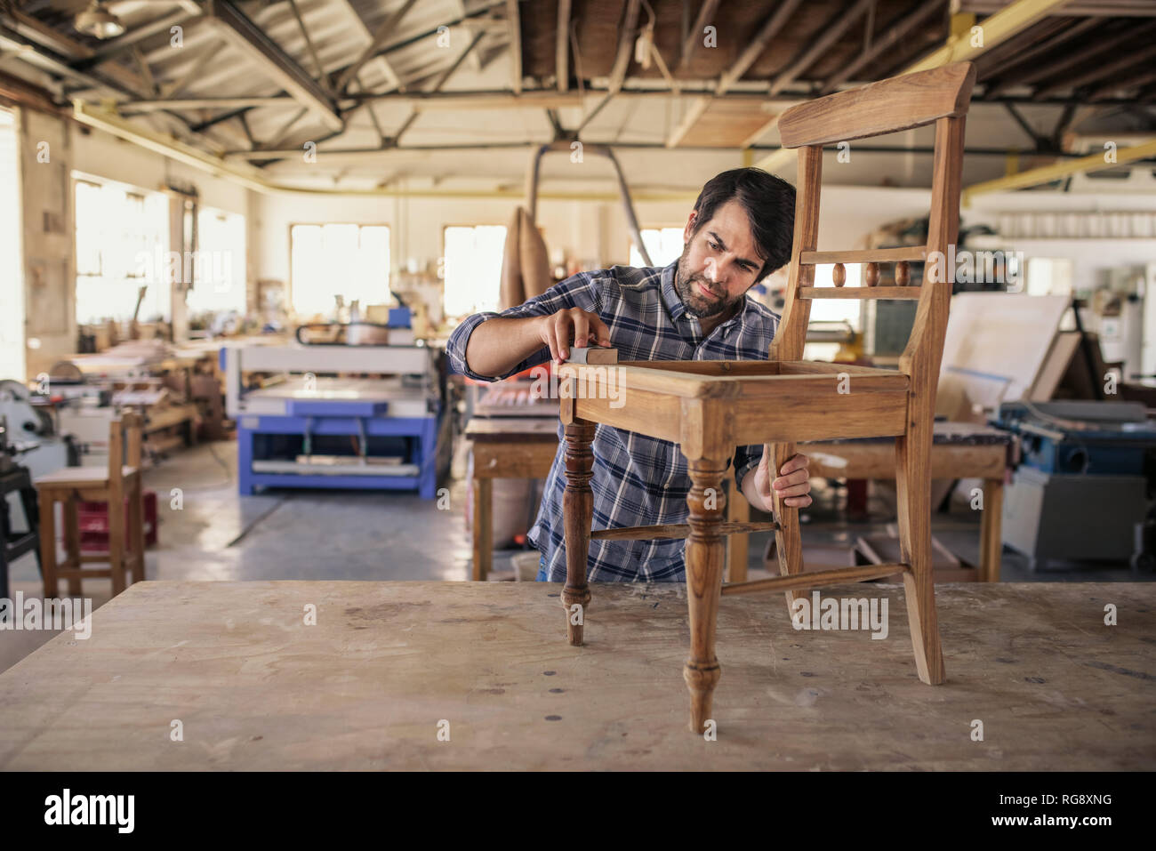 Furniture maker sanding a chair on bench Stock Photo Alamy