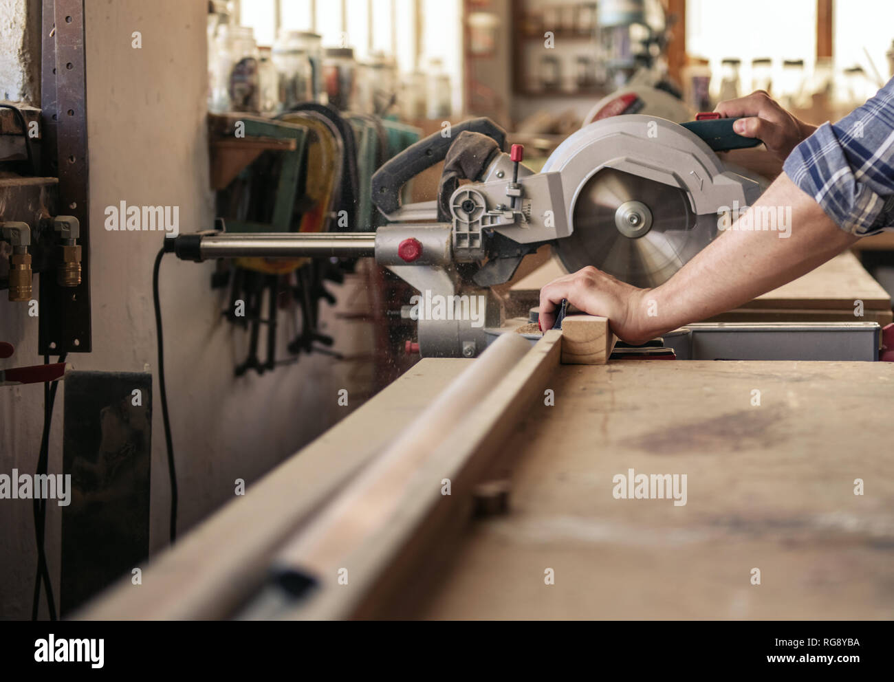 Craftsman cutting wood with a mitre saw in his Stock Photo Alamy