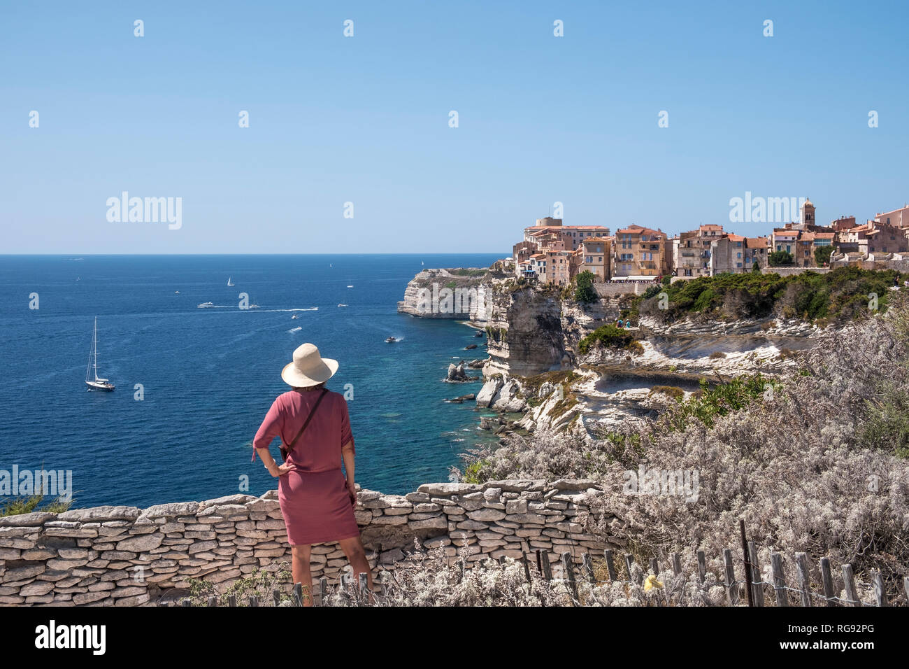 Corsica, Bonifacio, woman standing on viewpoint looking to the city Stock Photo