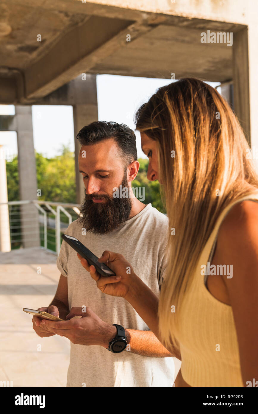 Young couple using cell phones in the city Stock Photo
