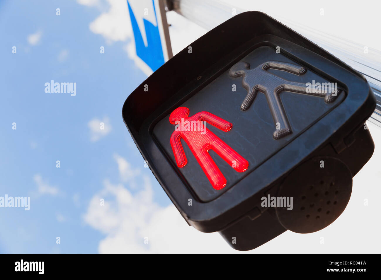 Pedestrian crossing traffic lights under blue cloudy sky show red stop signal Stock Photo