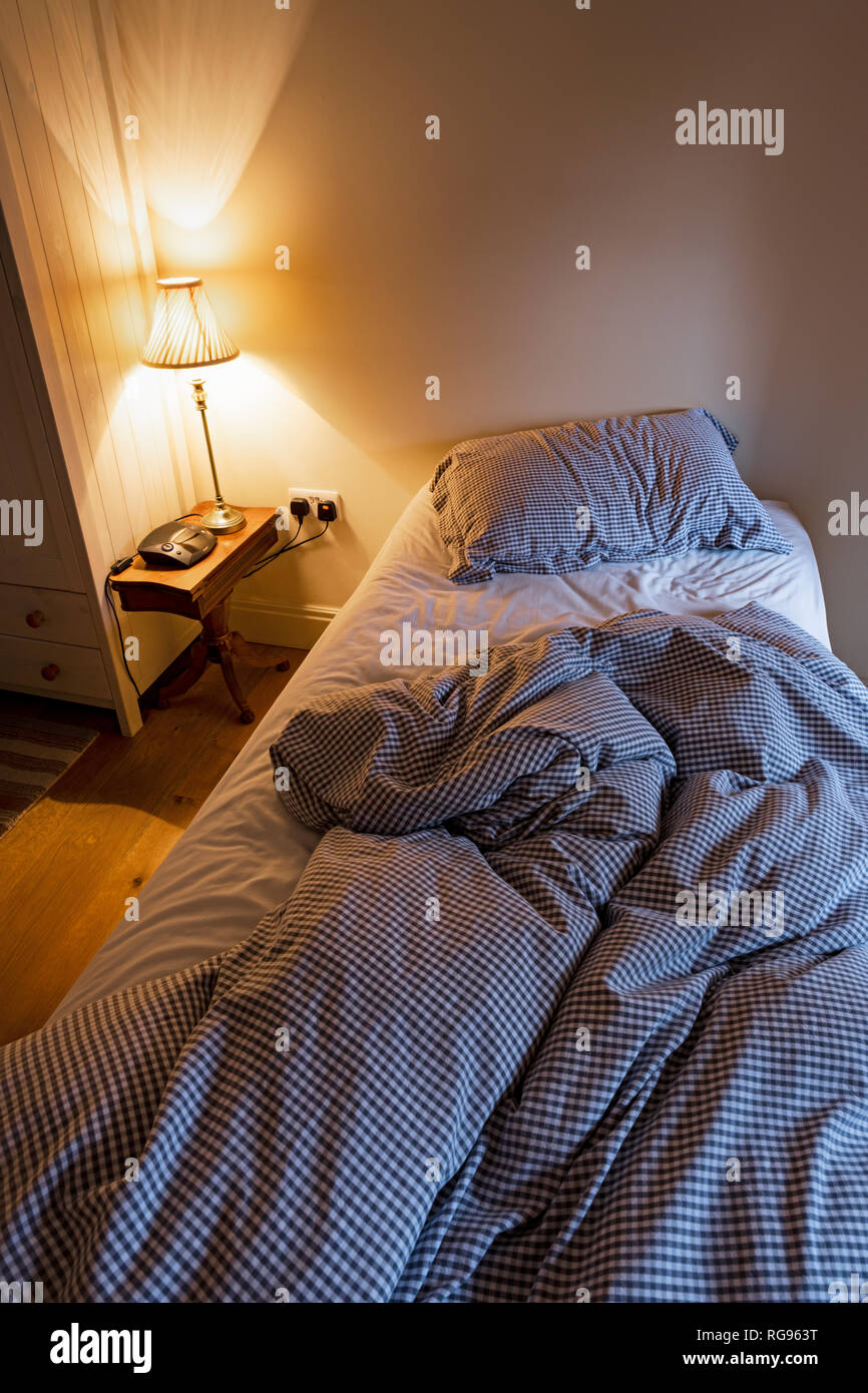 An unmade single bed. Stock Photo