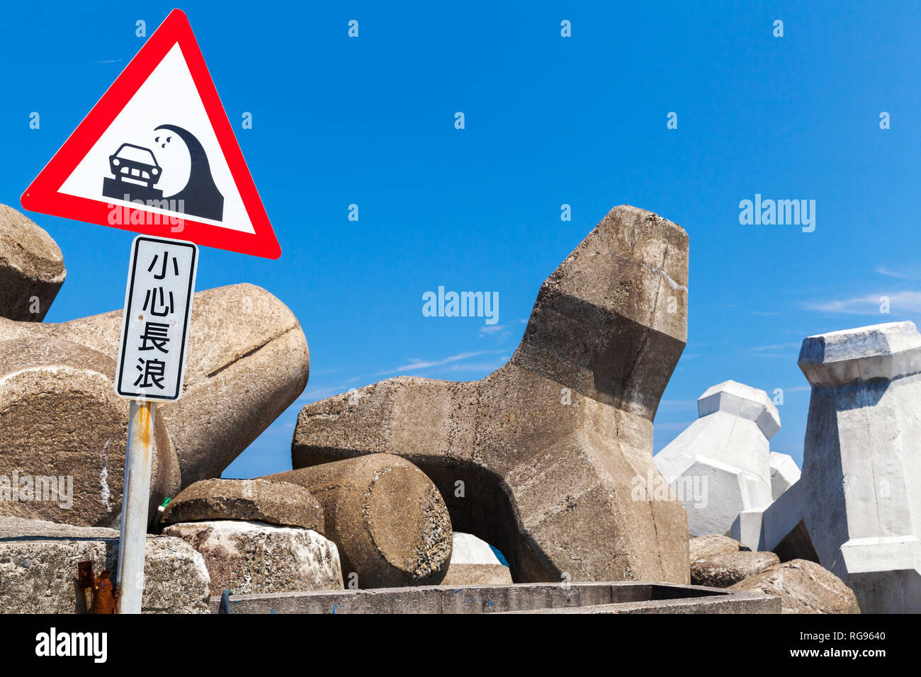 Caution Big Waves. Chinese road sign mounted on breakwater. Text label means: be careful with long waves Stock Photo