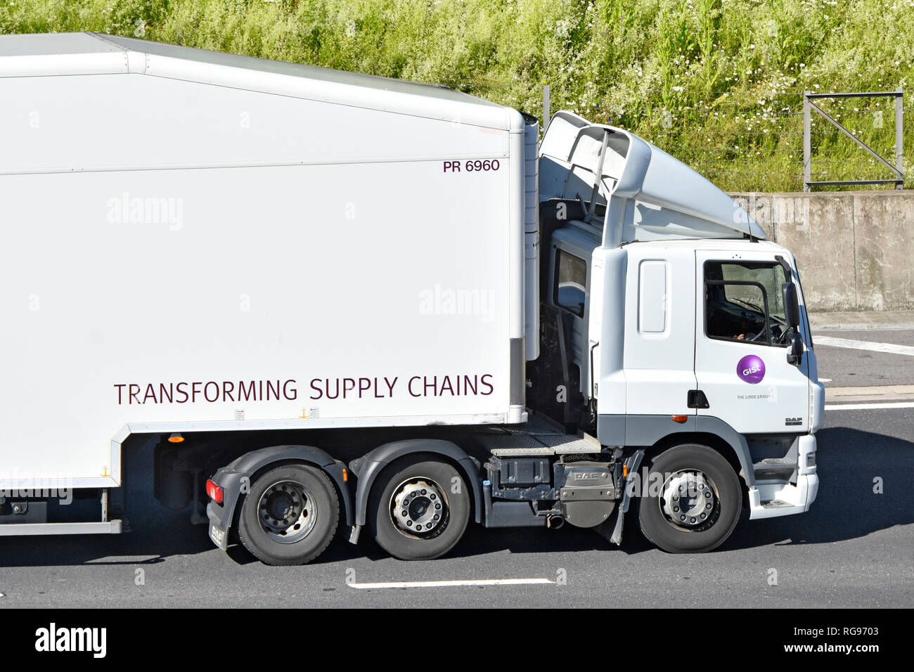 Close up side view of Gist white hgv streamlined lorry truck cab & part of articulated trailer & Transforming Supply Chain slogan on road England UK Stock Photo