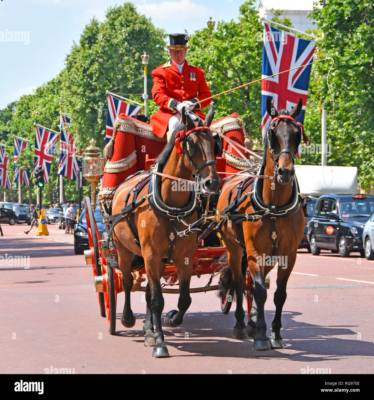 Close up front horse drawn four wheeled State Landau carriage in The Mall union jack flags coachman in uniform convey diplomatic dignitaries London UK Stock Photo