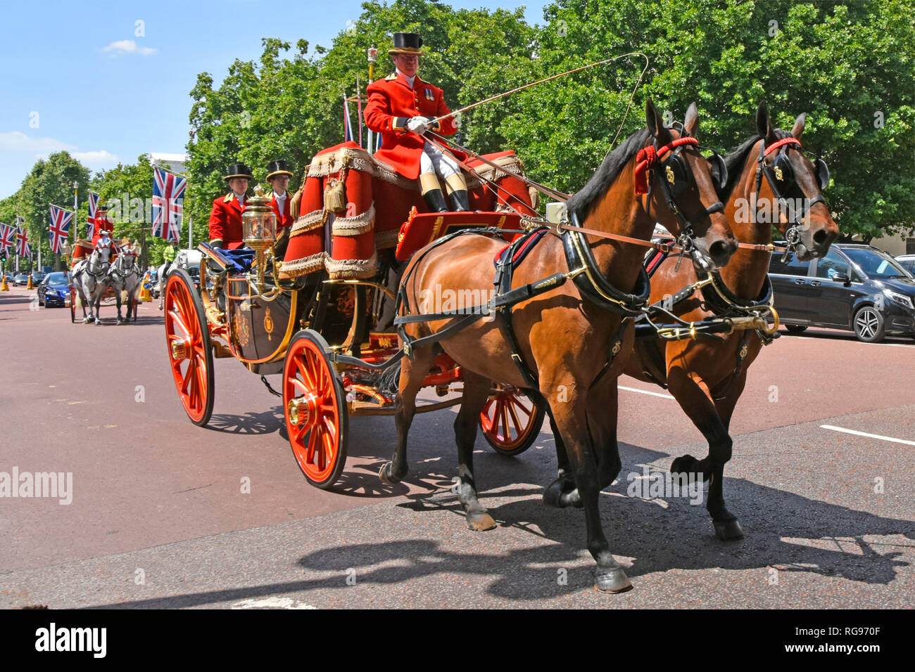 Close up two horse drawn State Landaus carriages in The Mall with coachman & two footmen in uniform transporting diplomatic dignitaries London UK Stock Photo
