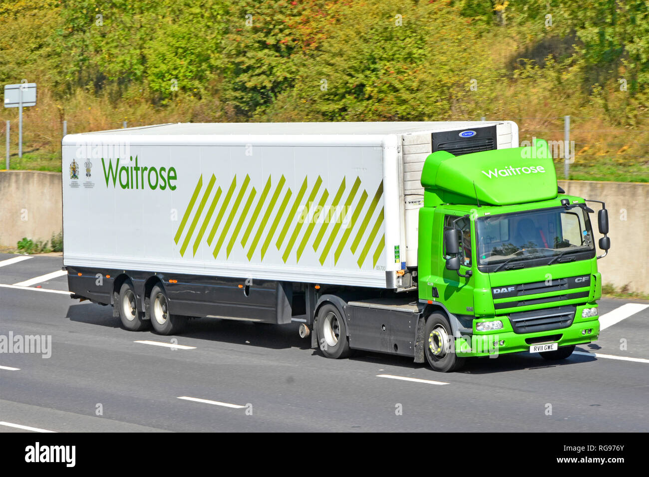 Side & front view Waitrose supermarket retail business food supply chain store delivery lorry truck & driver trailer logo & Royal Warrant England UK Stock Photo