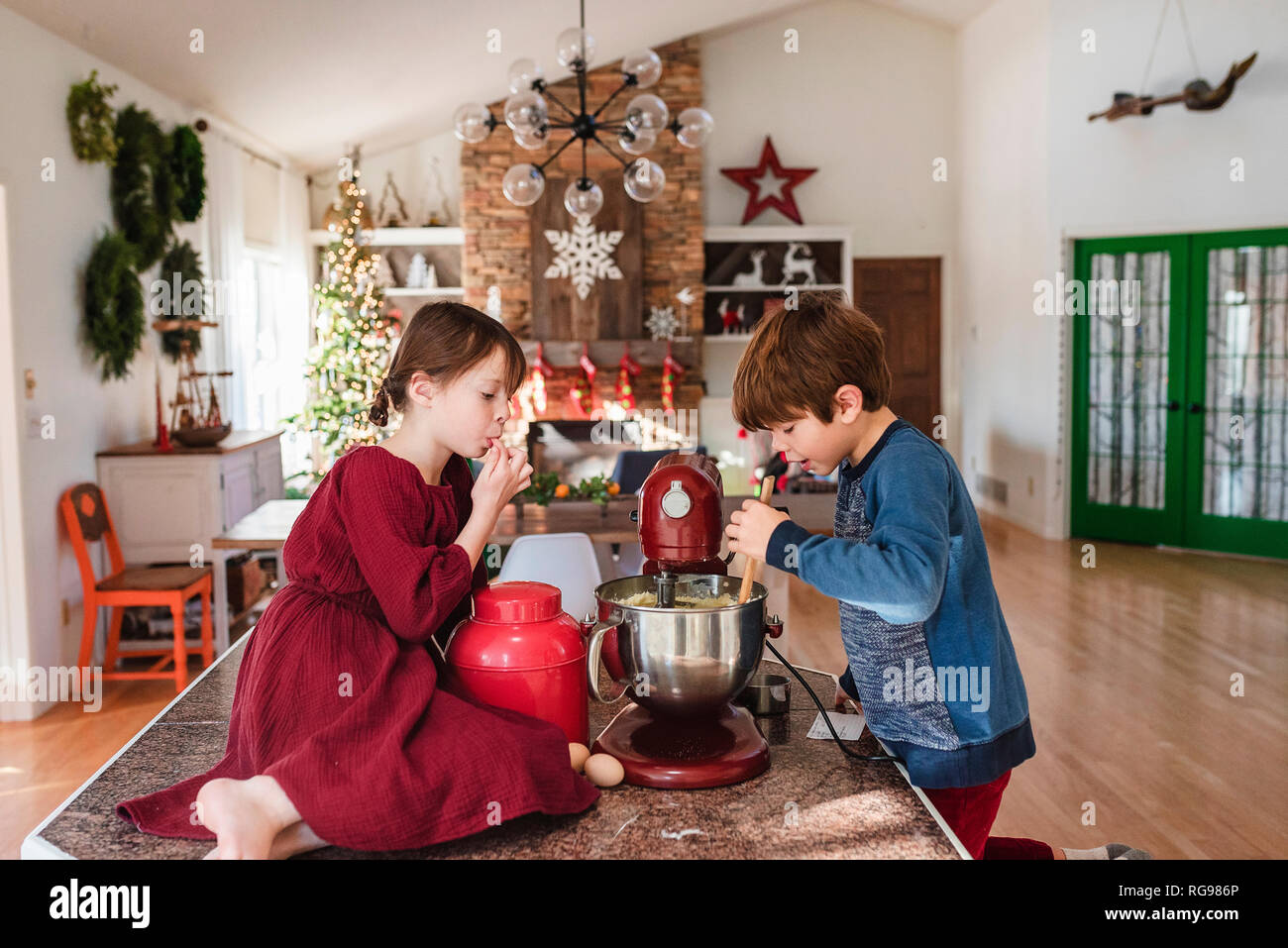 Two children in the kitchen making a cake Stock Photo