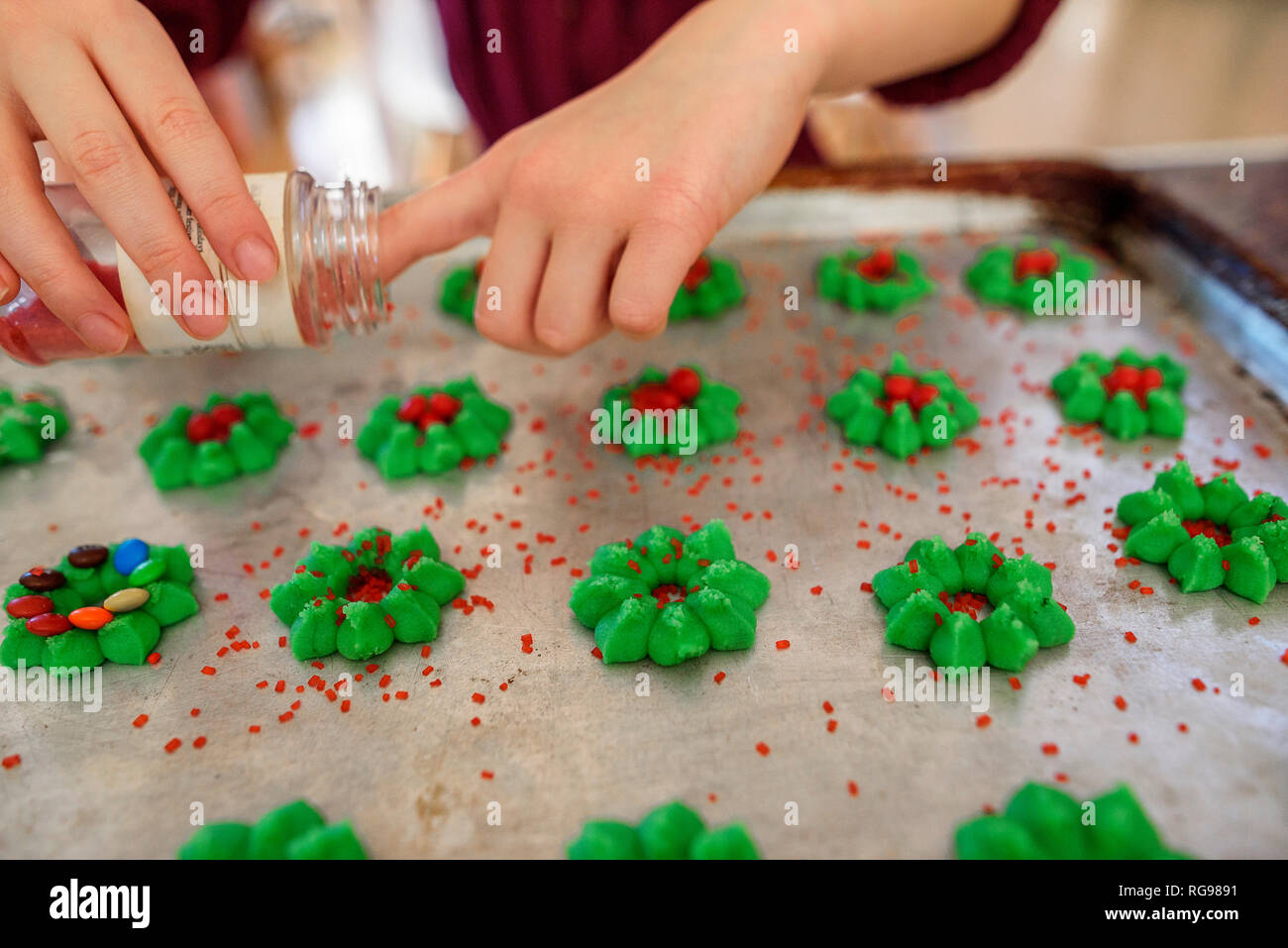 Girl standing in the kitchen decorating Cookies Stock Photo
