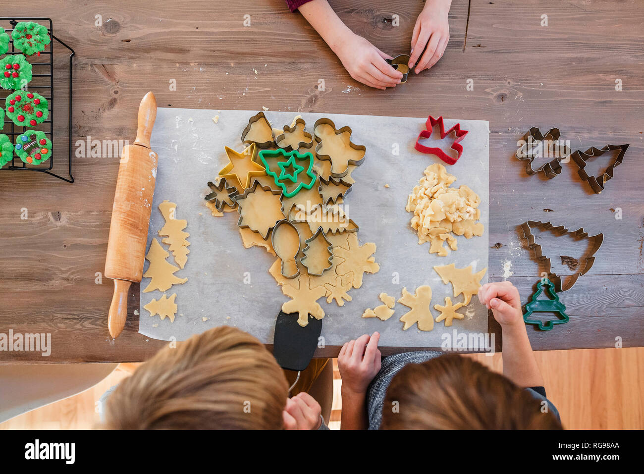 Overhead view of three children making Christmas cookies Stock Photo