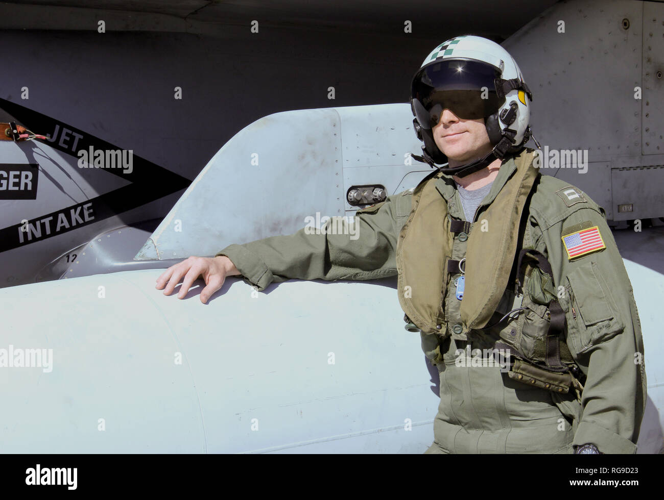 U.S. Navy Fighter Pilot in full flight gear standing next to his F-18  Fighter Jet Stock Photo