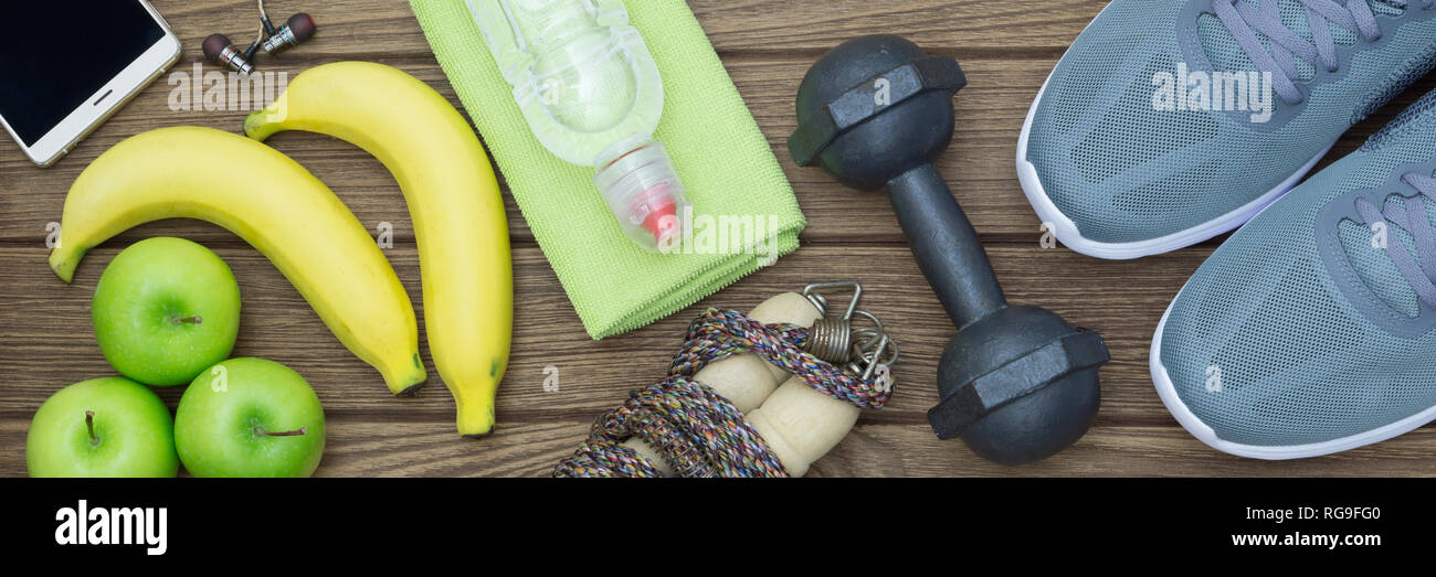 Top view of Healthy lifestyle concept, sport equipments and fresh foods on wood background.  Web Banner. Stock Photo