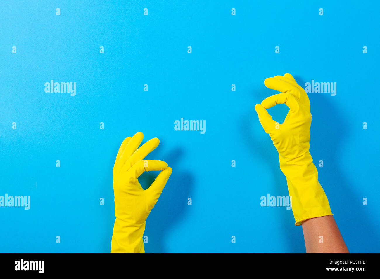 Woman hands with yellow rubber gloves making a gesture meaning ok, top