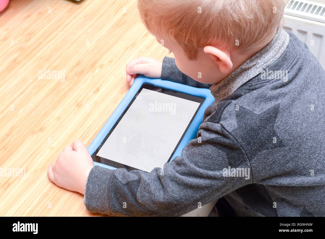 Child using a tablet device to learn and play games, model is young boy ...