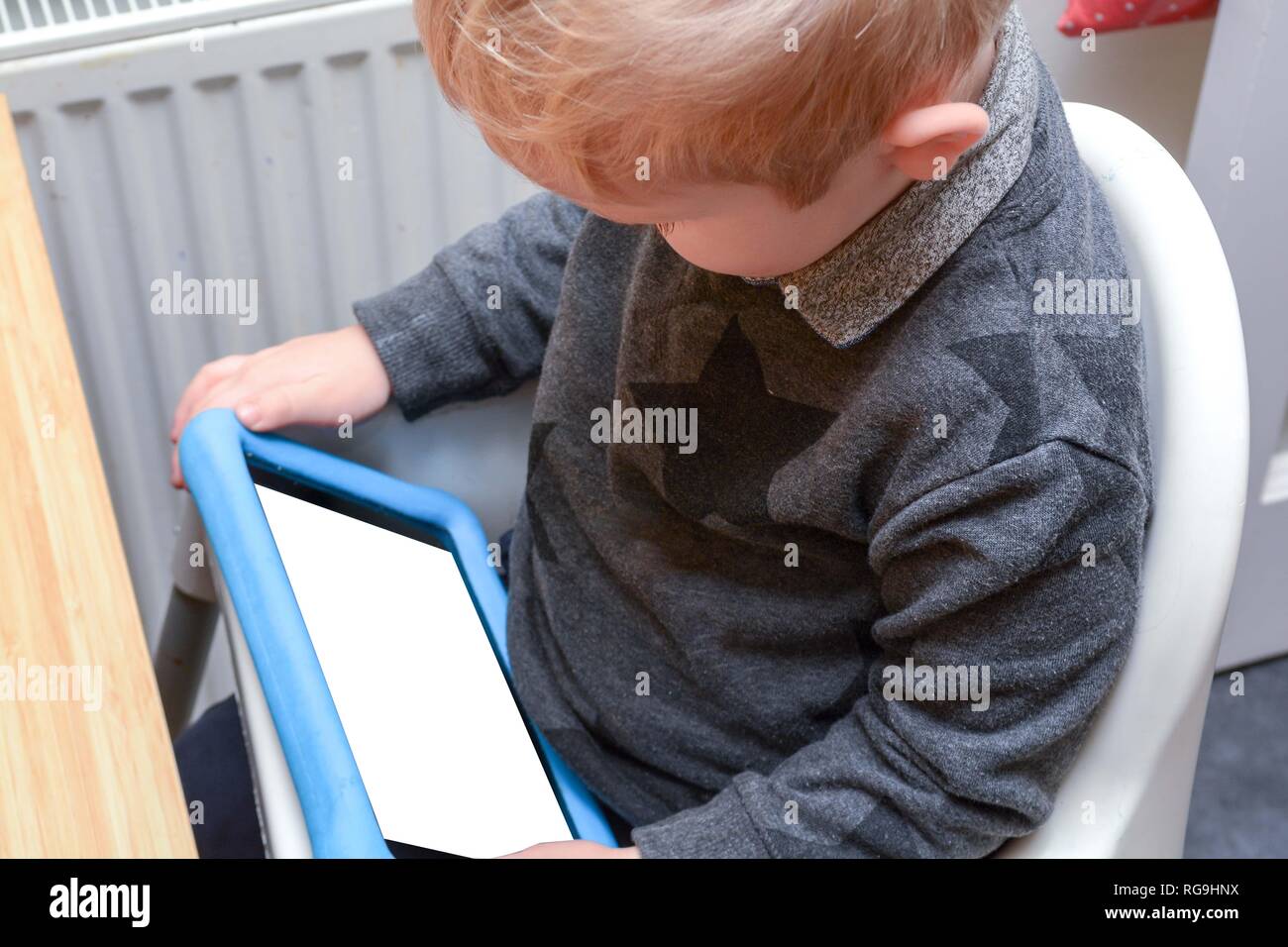 Child using a tablet device to learn and play games, model is young boy ...