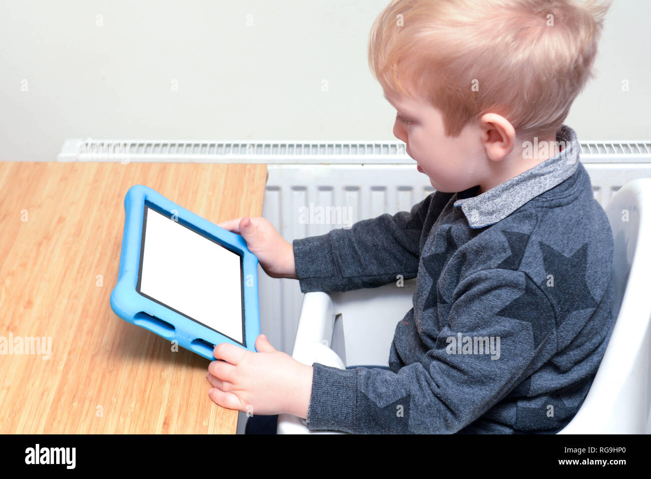 Child using a tablet device to learn and play games, model is young boy ...