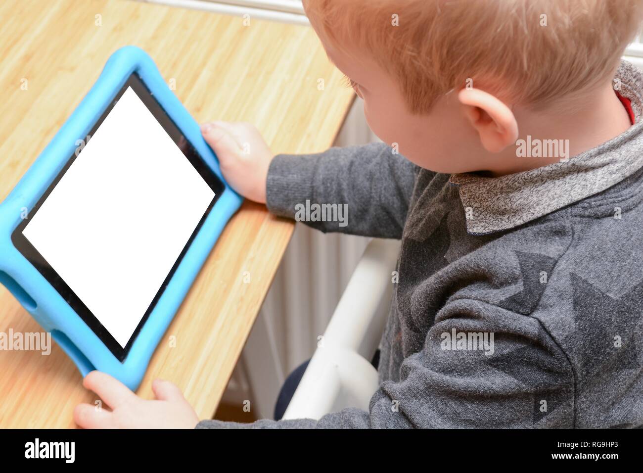 Child using a tablet device to learn and play games, model is young boy ...