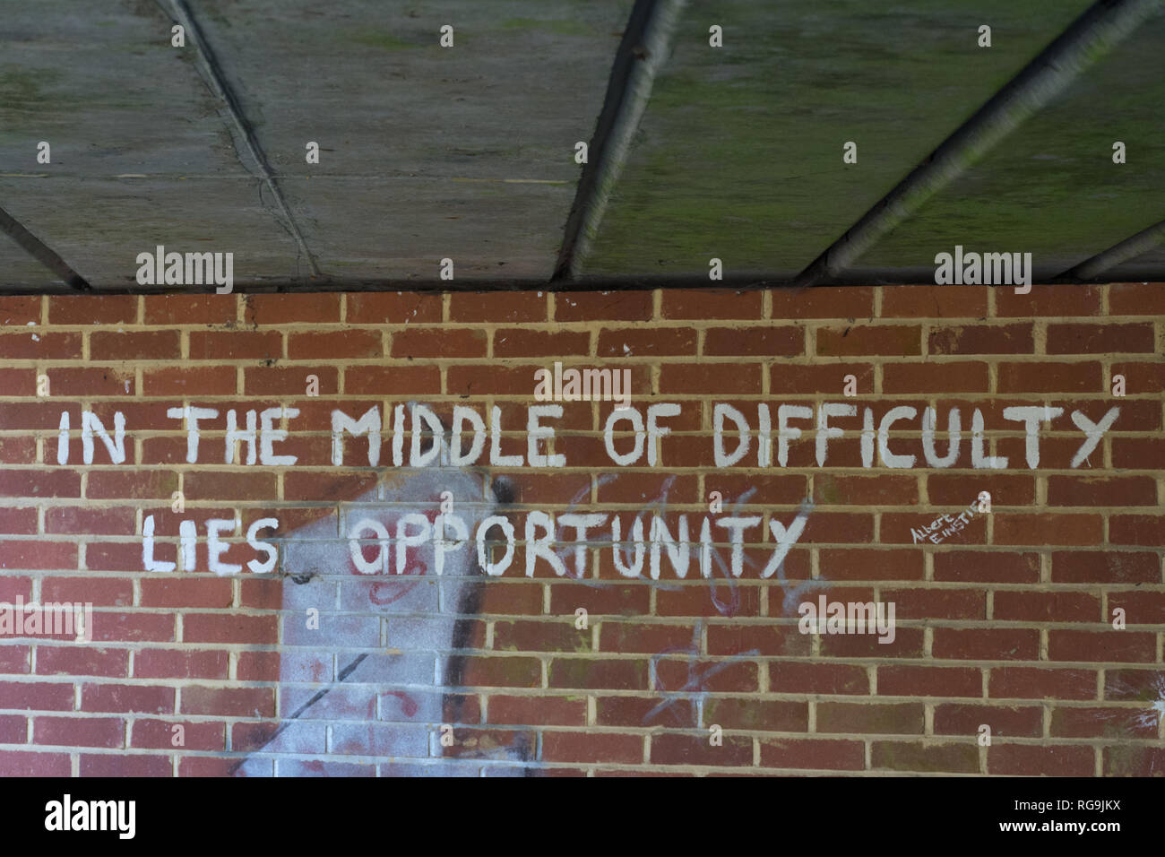 Graffiti under a bridge - In the middle of difficulty lies opportunity - a quote (quotation) from Albert Einstein. Inspirational thought or idea. Stock Photo