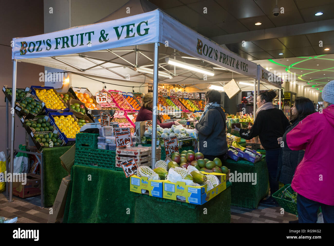Fruit and vegetable market stall in Woking town centre, Surrey, UK, with people shopping. Everyday life. Stock Photo