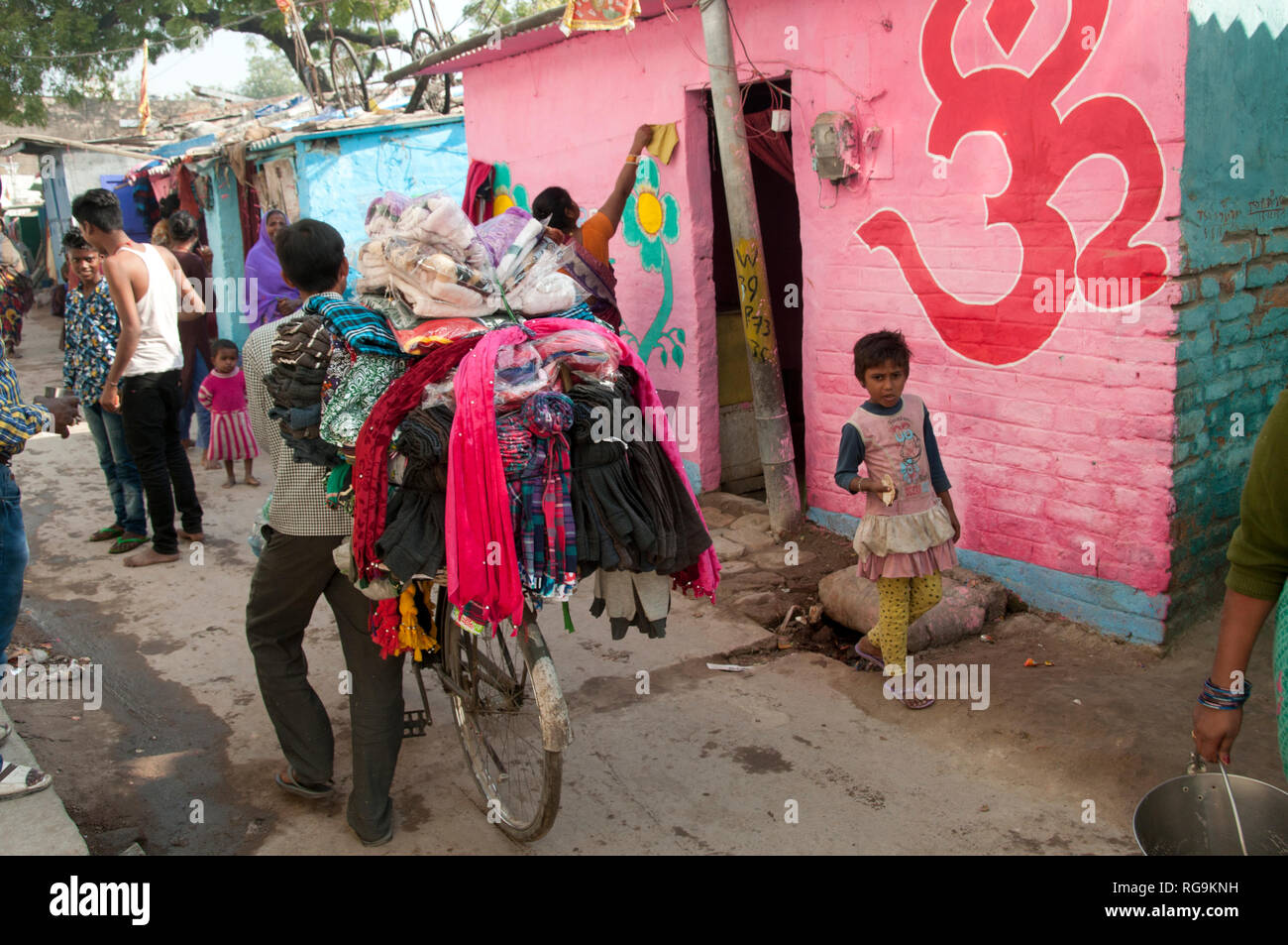 India. Bihar. Muzaffarpur.Purani Gudri (old slum). A travelling salesman with his wares (clothing) on his bicycle. Stock Photo