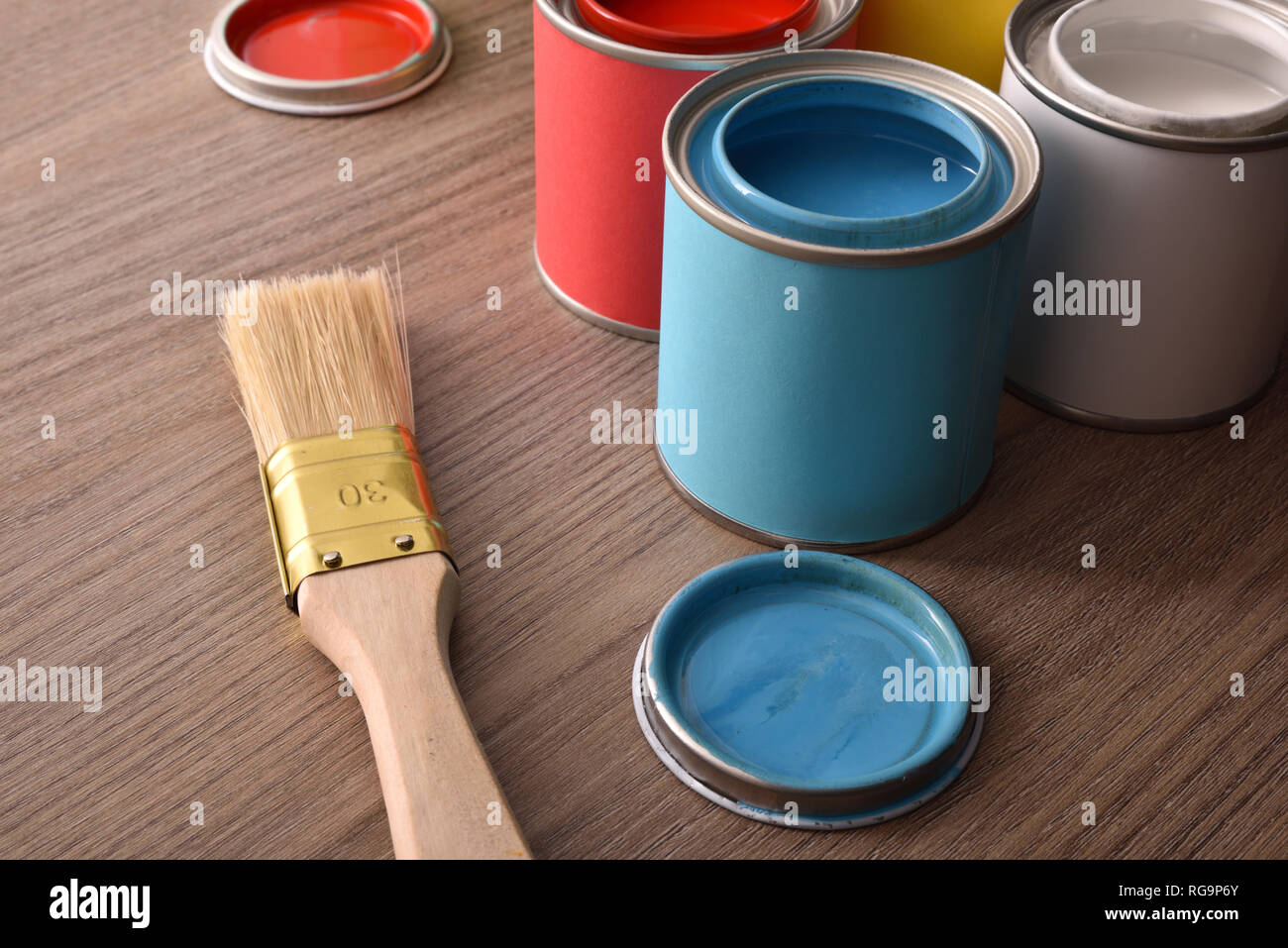 Assortment open paint cans and their covers on wooden table. Elevated ...
