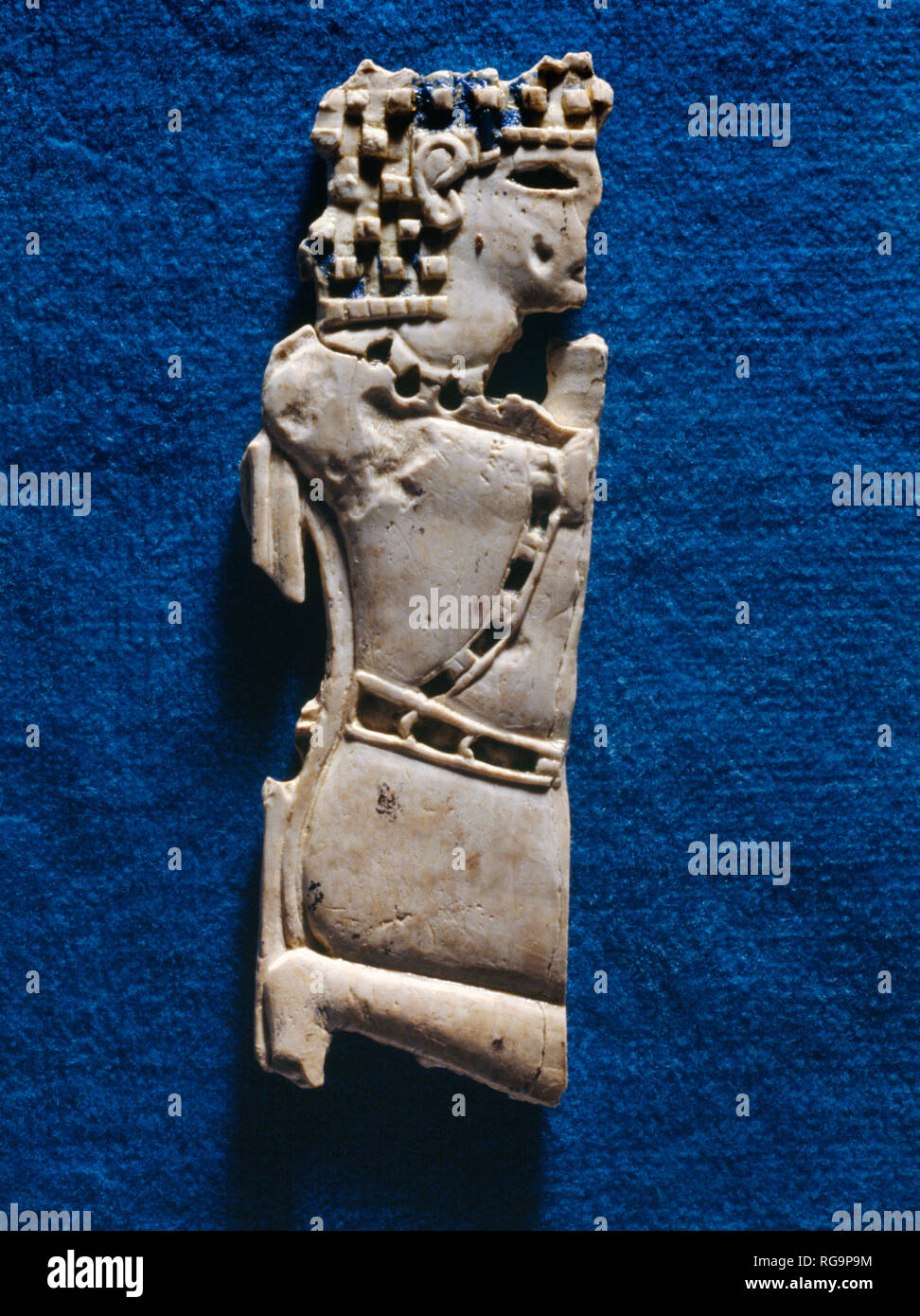 Kneeling male figure: Nimrud Ivory from Room SW37 Fort Shalmaneser within the Assyrian city of Nimrud, Iraq, photographed in the Iraq Museum, Baghdad. Stock Photo