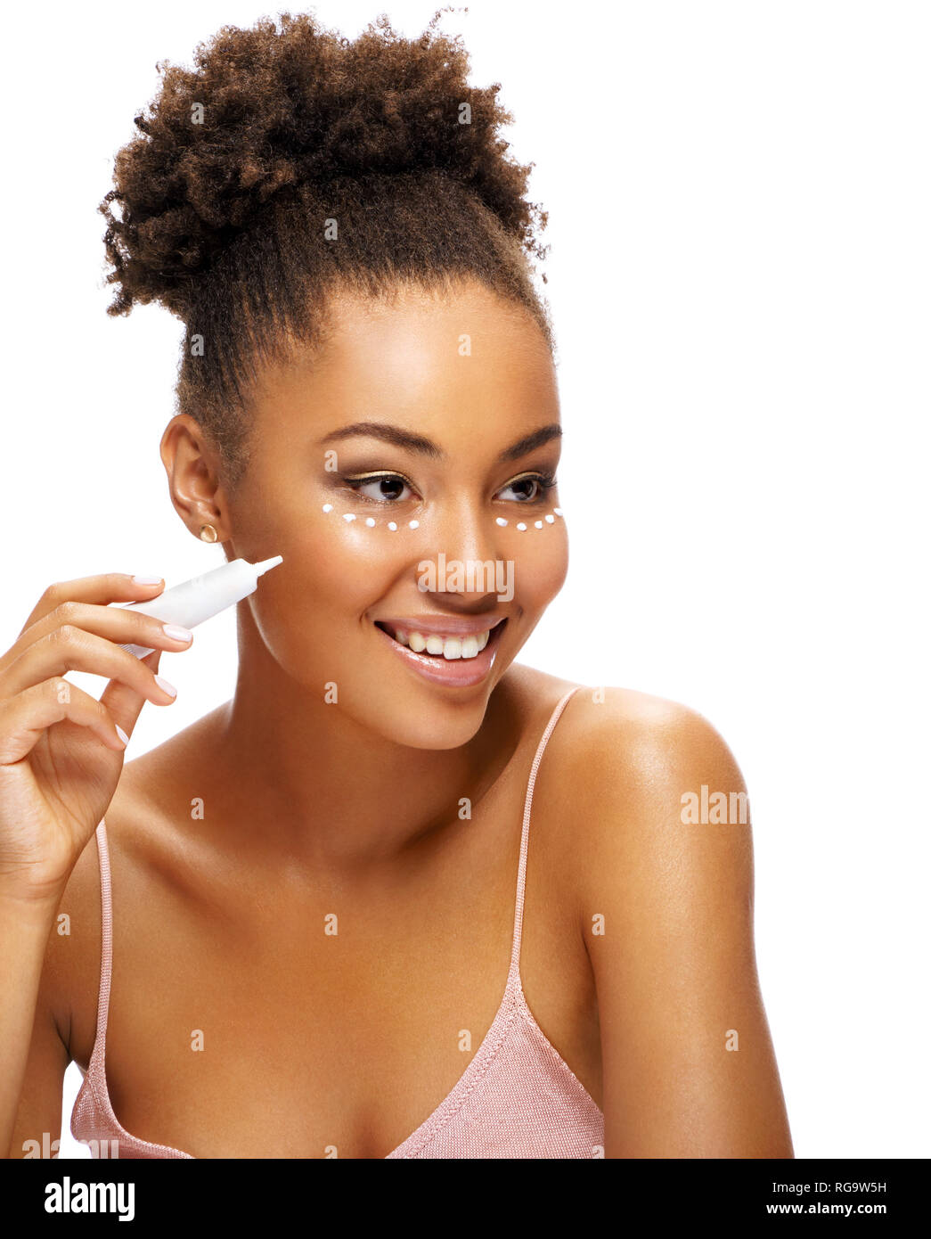 Pretty young girl with flawless skin using cream around the eyes. Photo of  smiling african american girl on white background. Skin care and beauty con  Stock Photo - Alamy