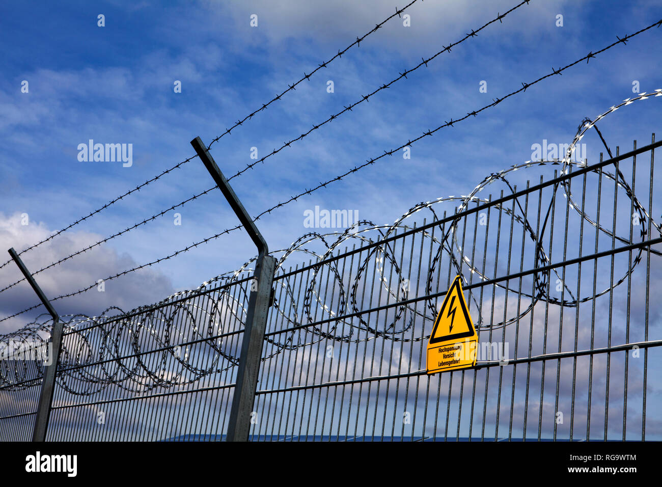 Signpost  and fence at an open space solar photovoltaic plant, Germany, Europe Stock Photo