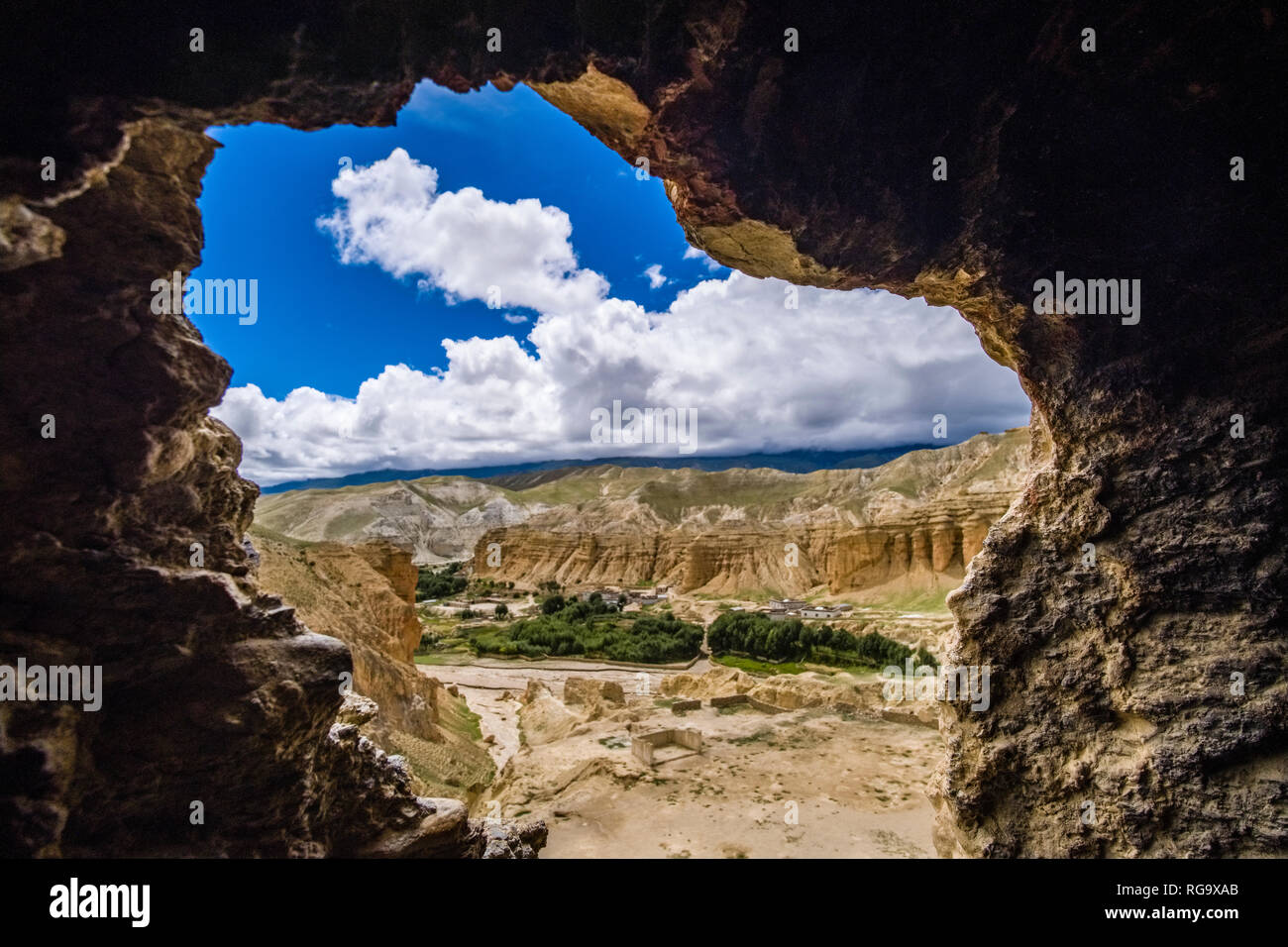 View out of one of the windows of Jhong Cave, the village and the barren landscape of Upper Mustang in the distance Stock Photo
