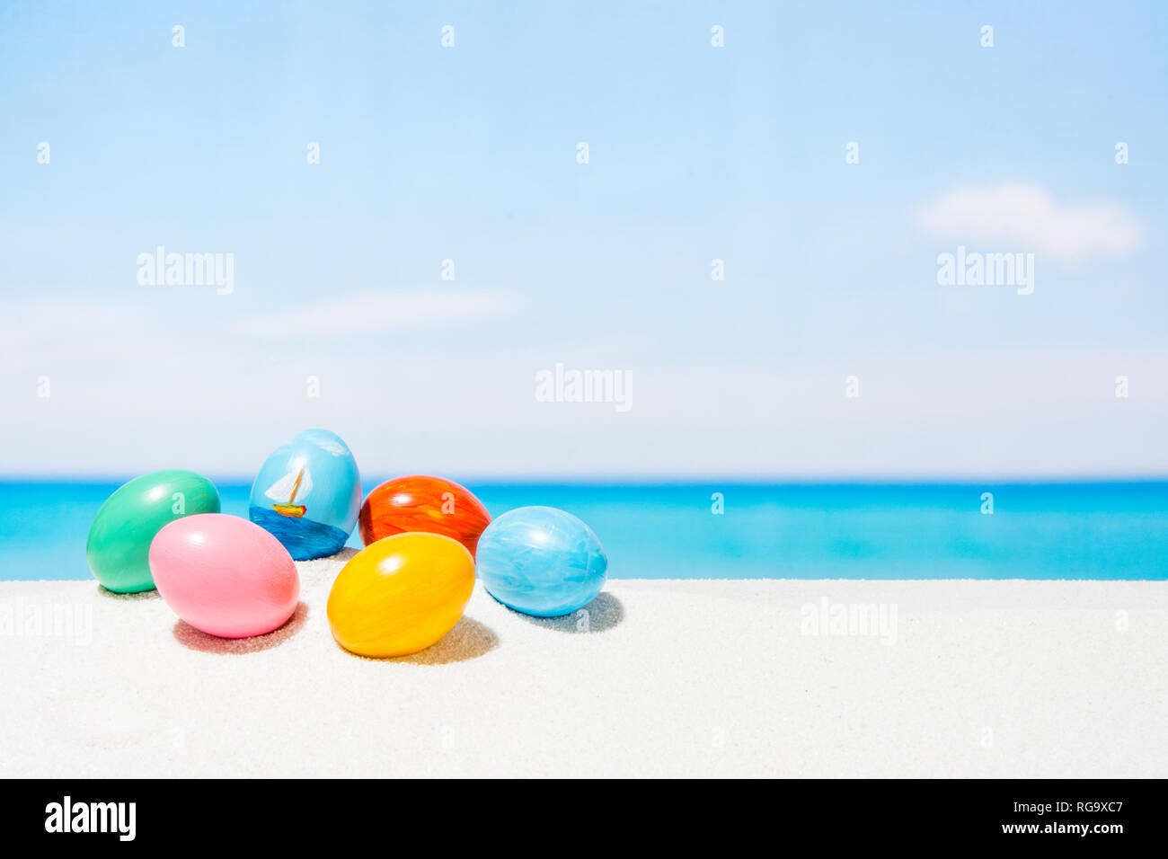 Easter on tropical beach background. Eggs on the white sand. Vacation and travel concept in spring Stock Photo
