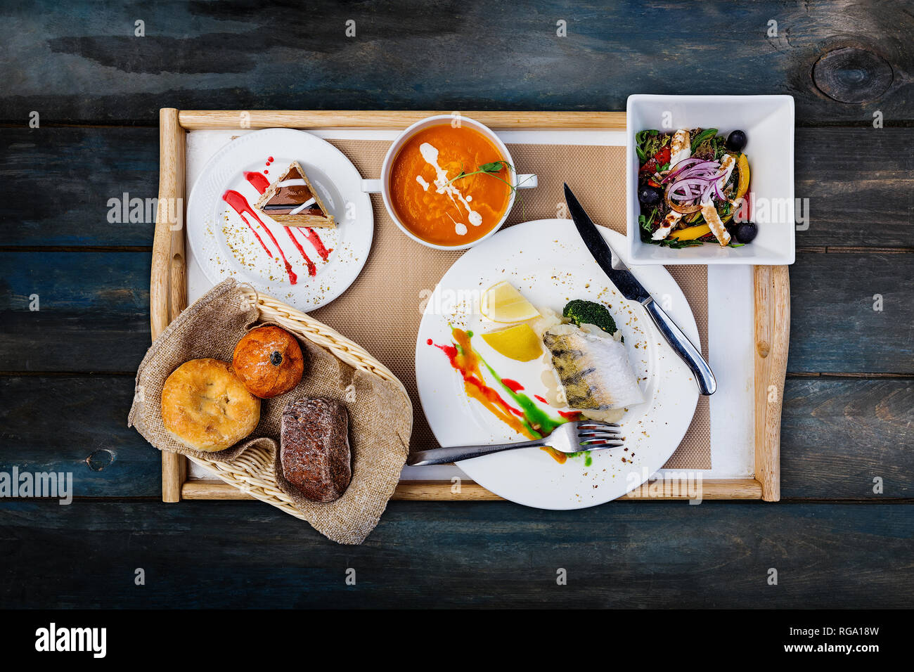 Lunch set. Steamed fish, pumpkin soup and vegetables salad, served with the cutlery. Stock Photo