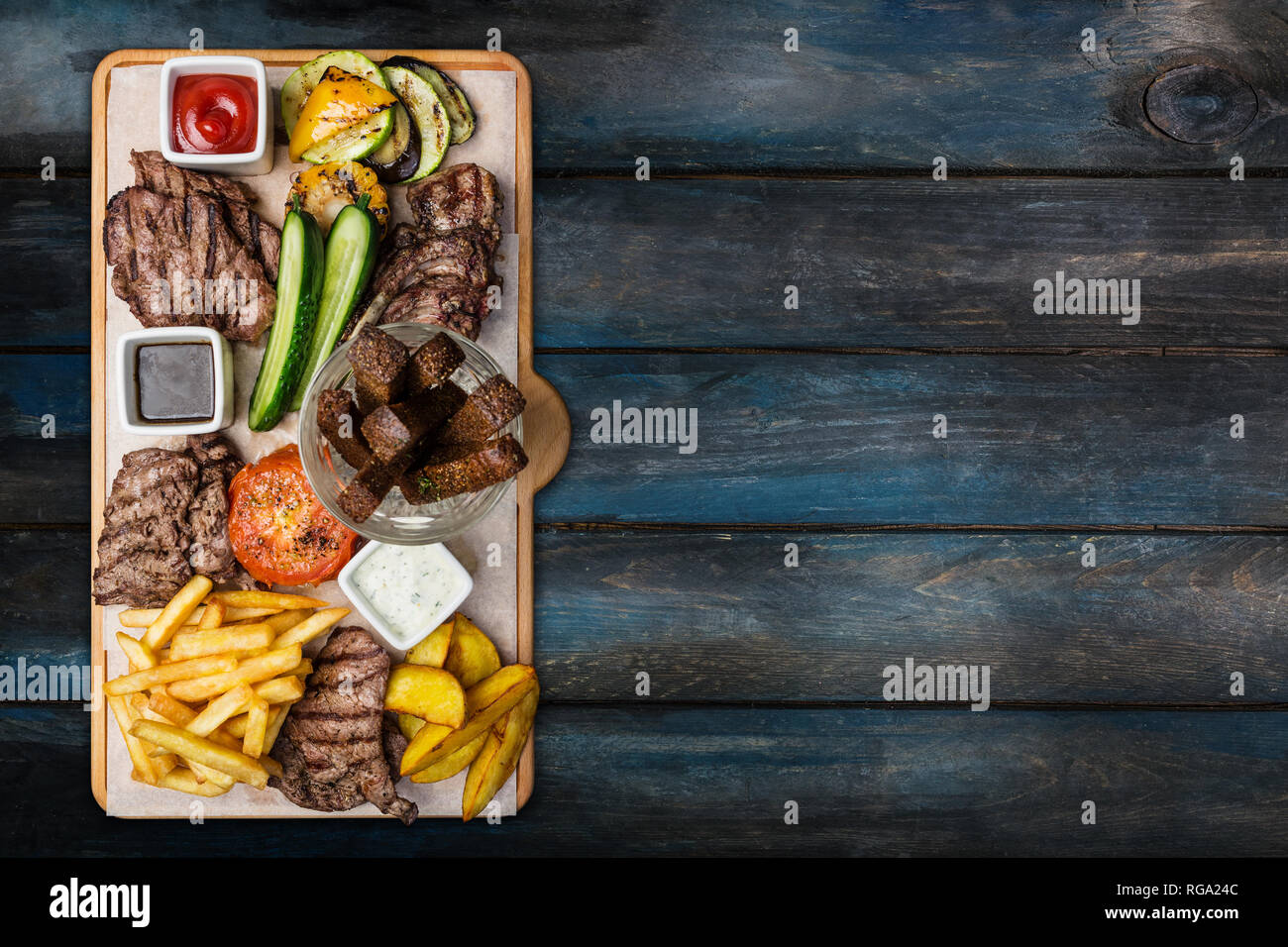 Beer snacks set. Meat set served on cutting board with the wooden background. Stock Photo