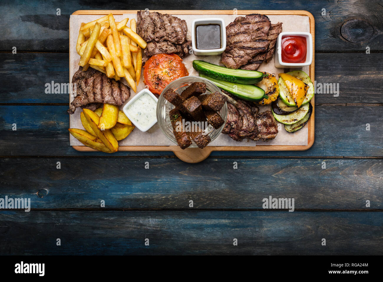 Beer snacks set. Meat set served on cutting board with the wooden background. Stock Photo