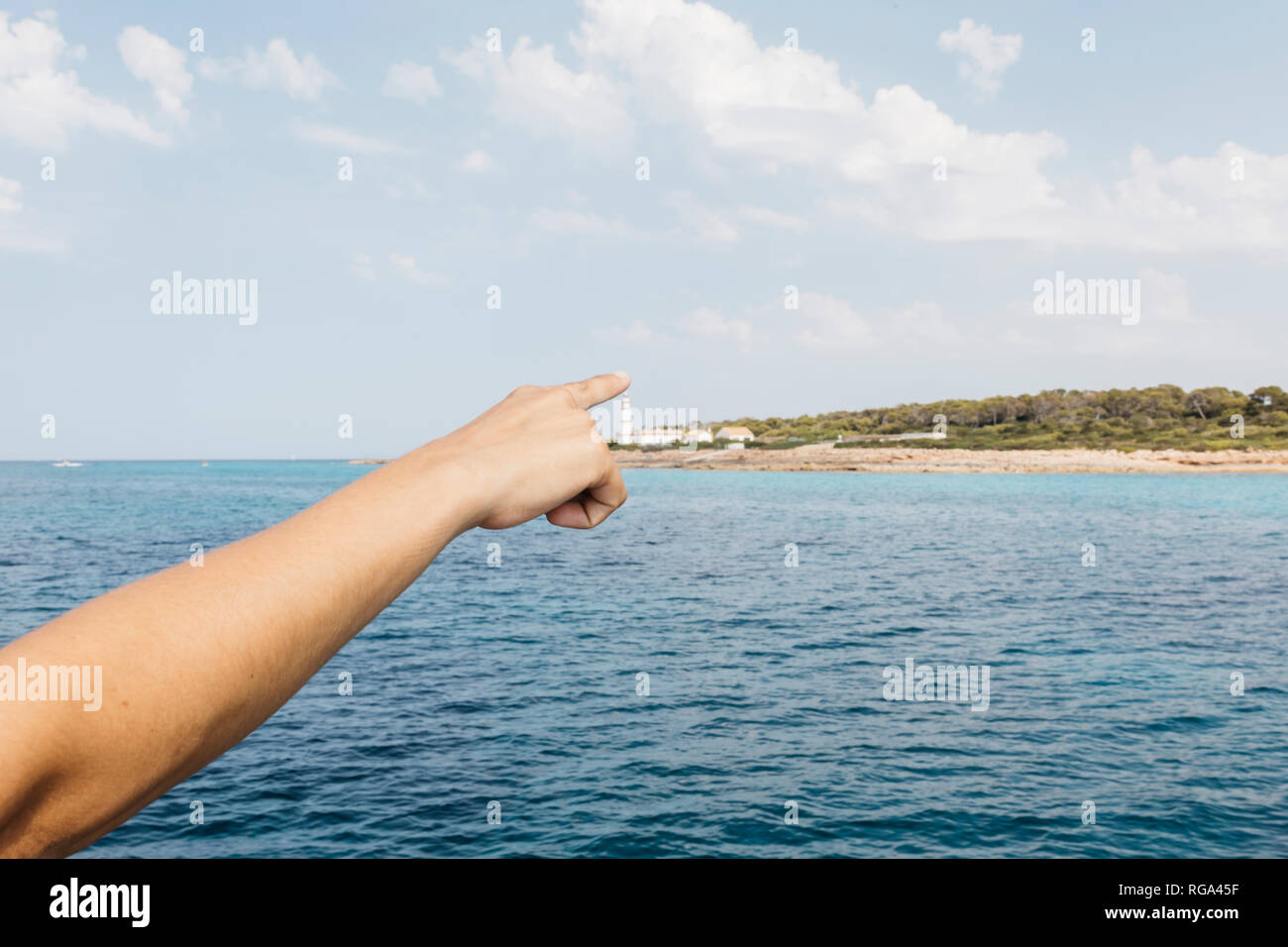 Woman's hand pointing at Cap Balnc lighthouse, Mallorca, Spin Stock Photo