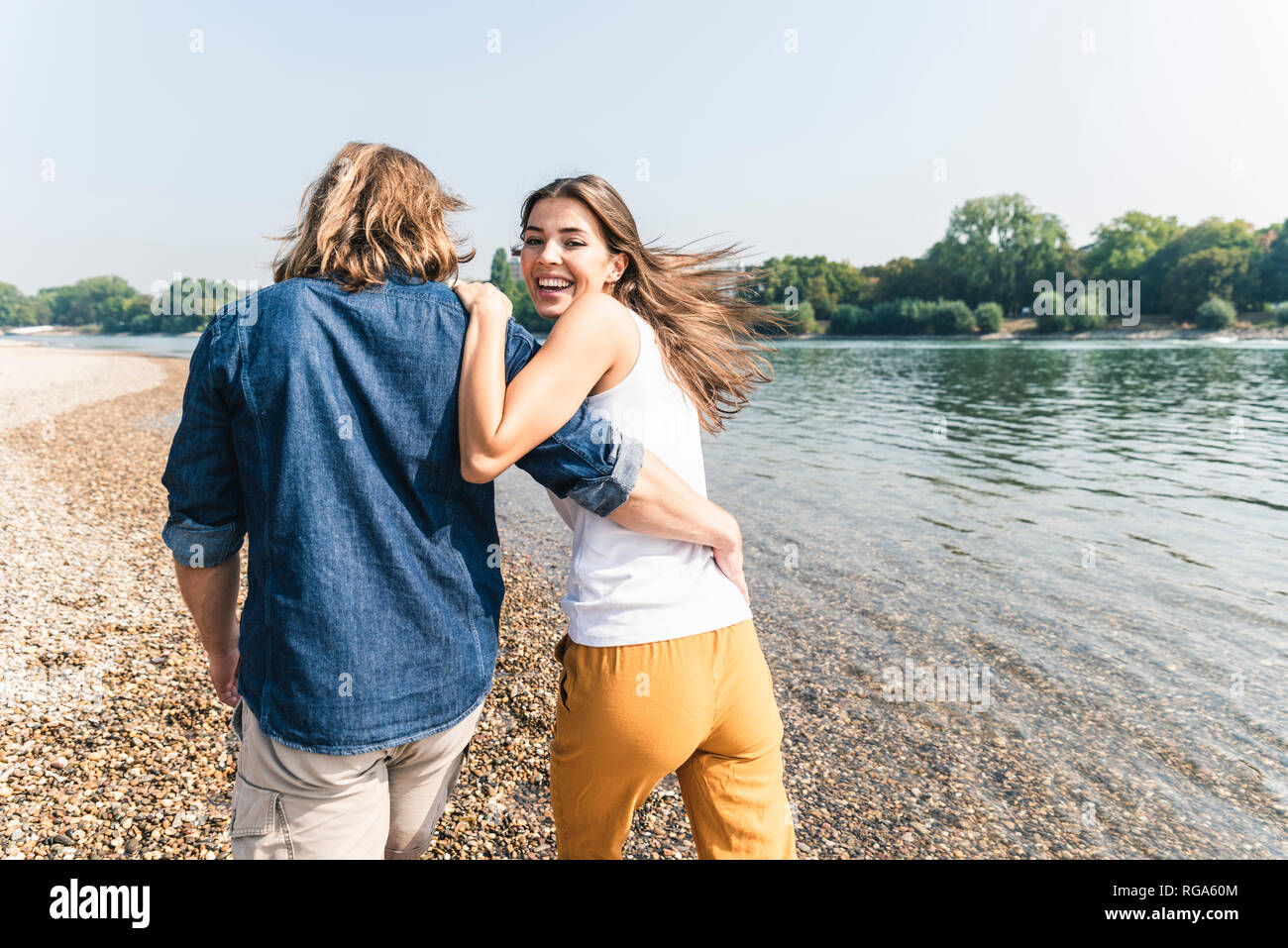 Happy young couple in love walking at the riverside Stock Photo