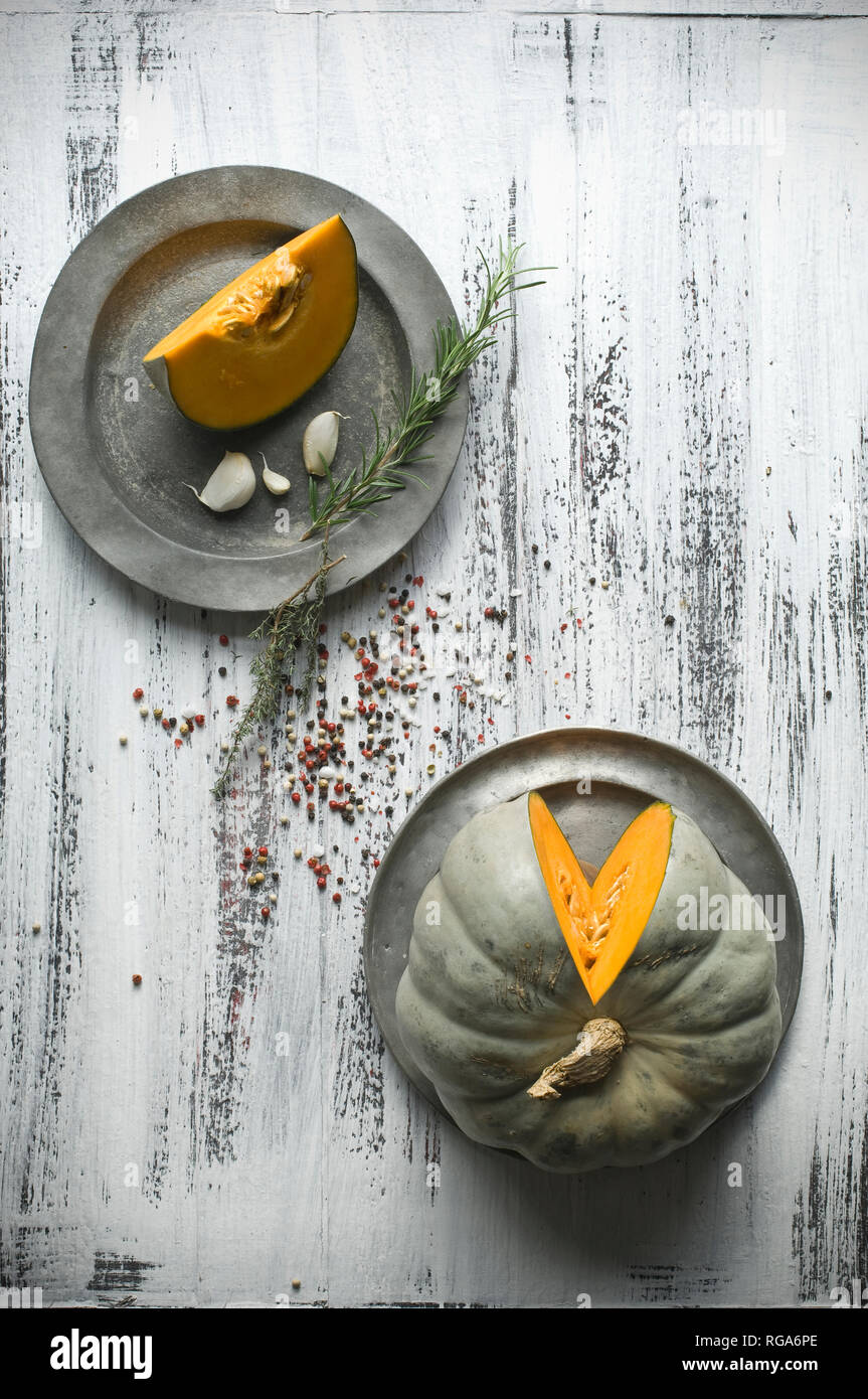 Sliced Cucurbita maxima on tin plates and spices for preparing pumpkin soup Stock Photo