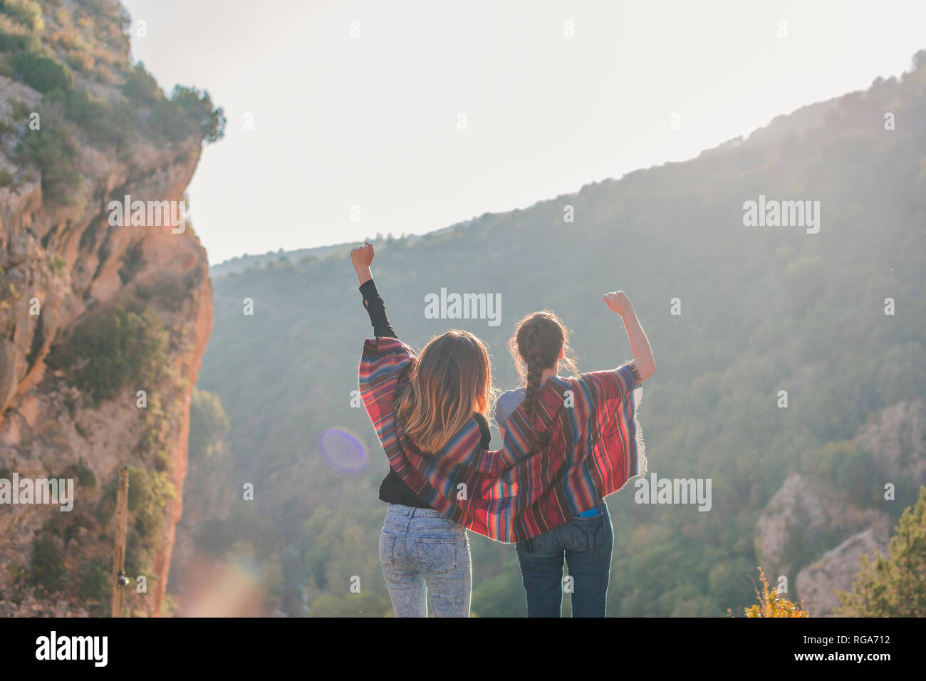 Spain, Alquezar, rear view of two young women on a hiking trip cheering Stock Photo