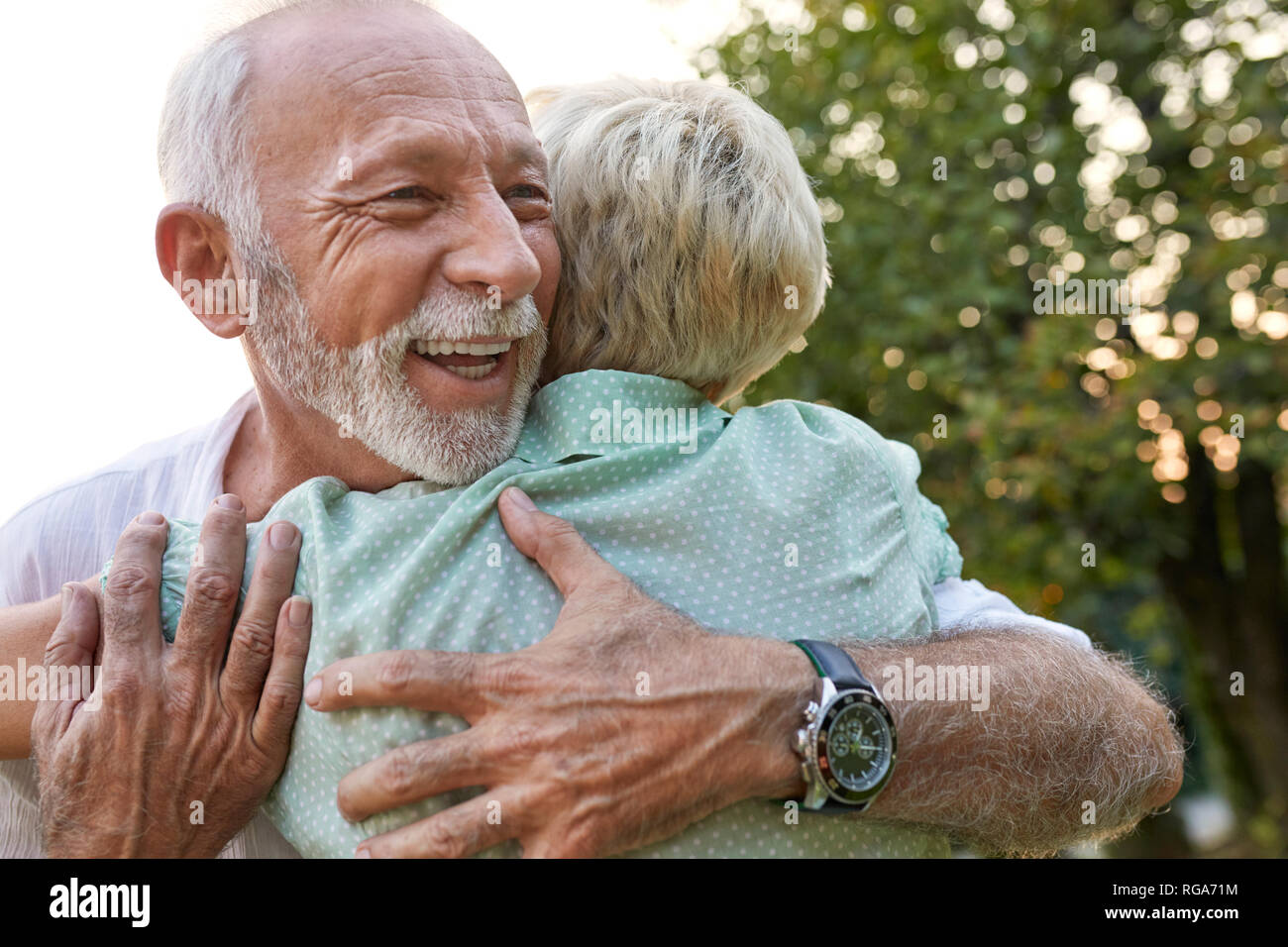 Happy senior couple hugging outdoors Stock Photo