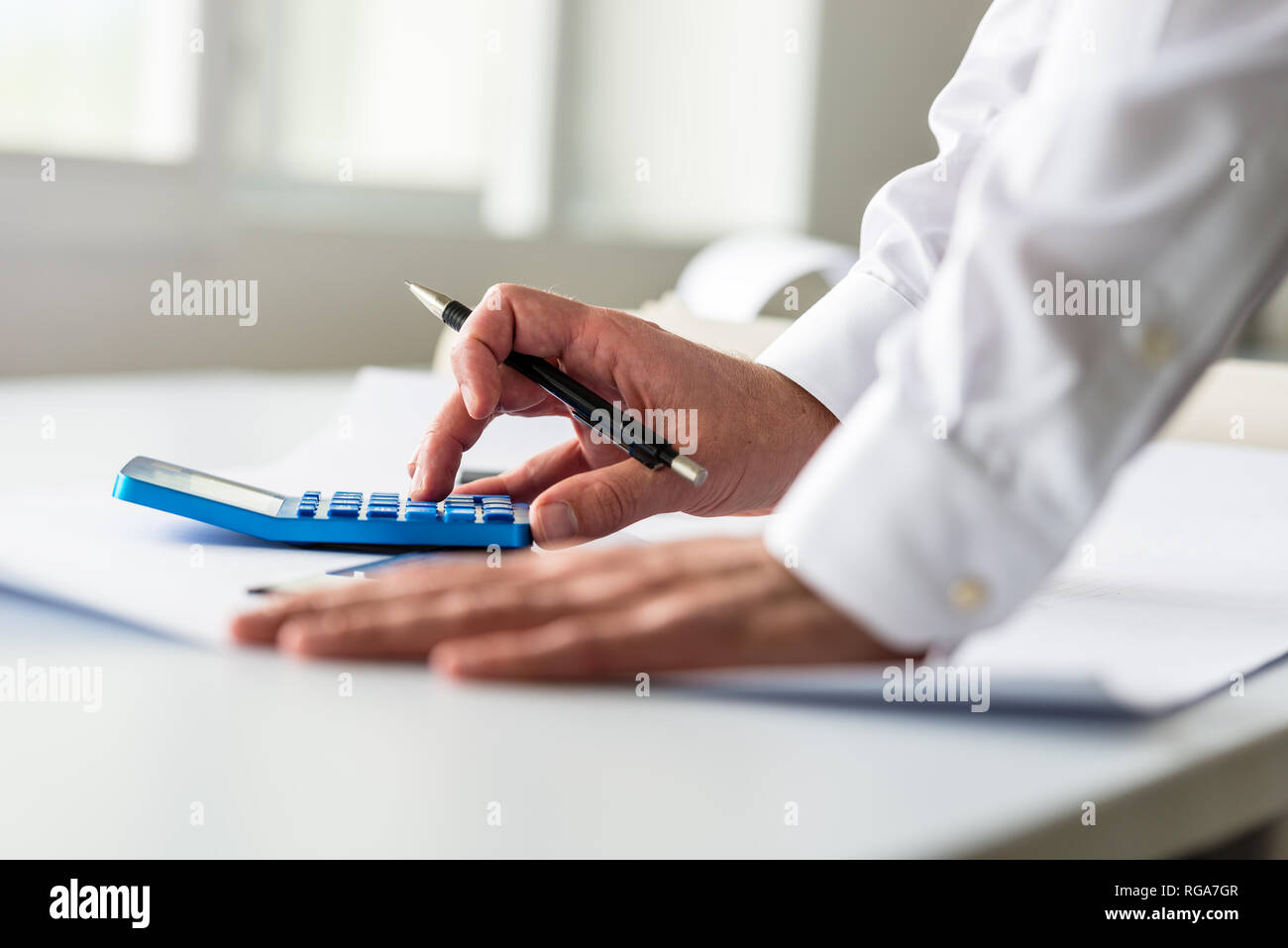 Closeup of engineer or architect working on a project using a calculator. Stock Photo