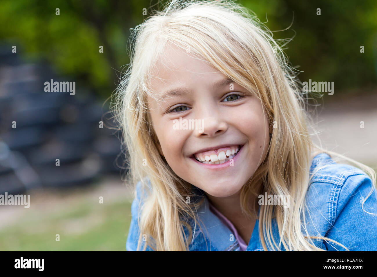 Portrait of smiling blond girl outdoors Stock Photo - Alamy