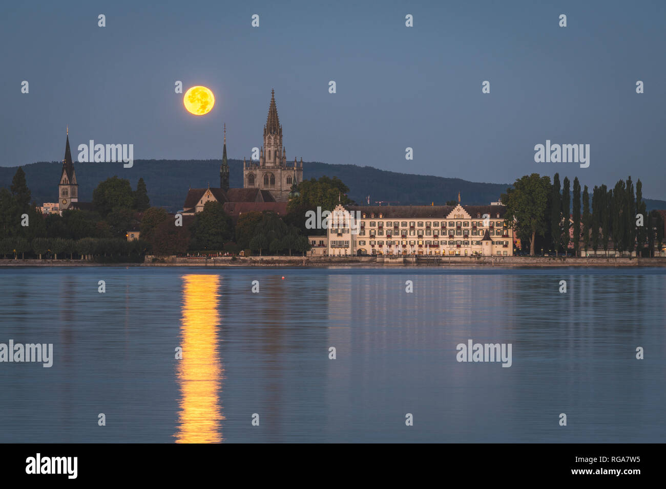 Germany, Baden-Wuerttemberg, Constance, Inselhotel and Constance minster during full moon Stock Photo